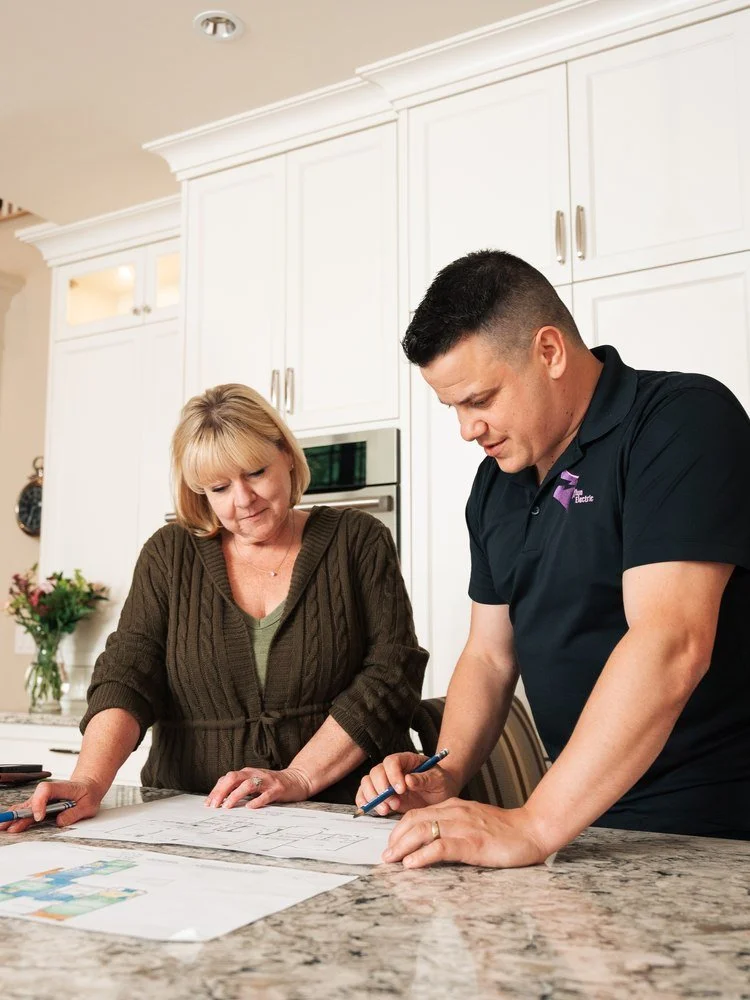 Grifflyn Electric electrician going over renovation plans with a homeowner at a kitchen island