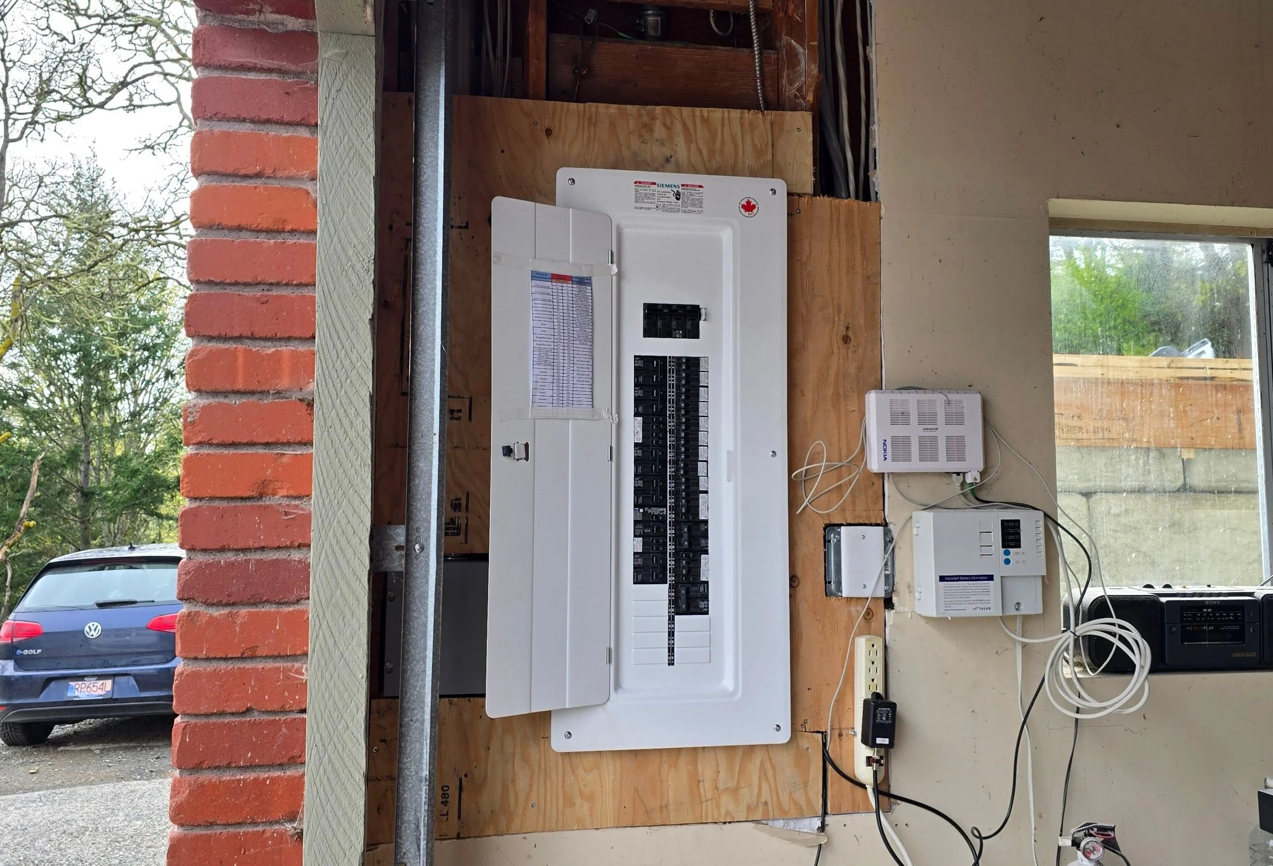Licensed electrician installing a new electrical panel in a Victoria home