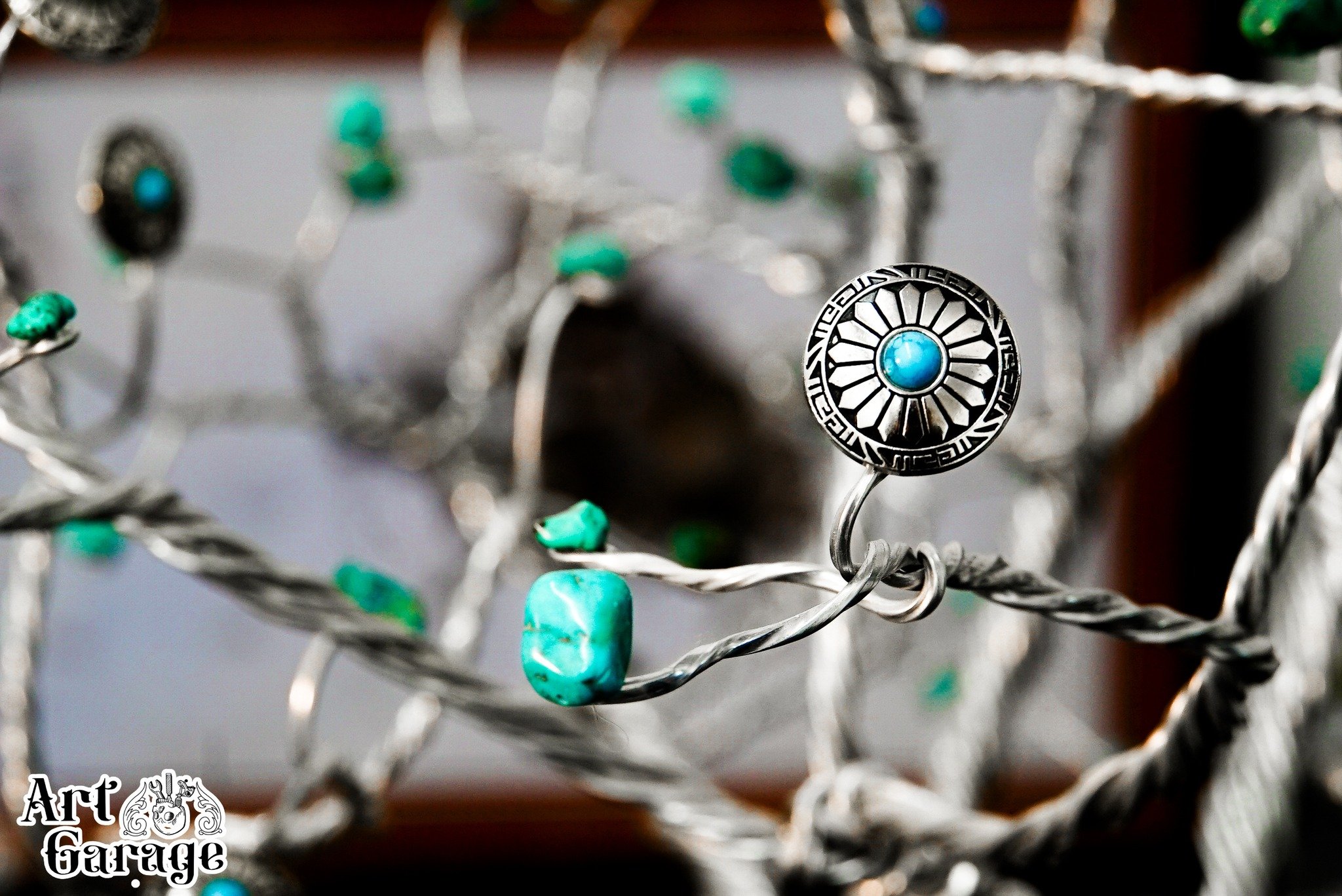 We are thrilled to showcase this stunning handmade sculpture created right here in the Art Garage by our talented owner, Chris Hamilton. This unique tree sculpture features beautiful turquoise chunks throughout, adding a touch of natural elegance and