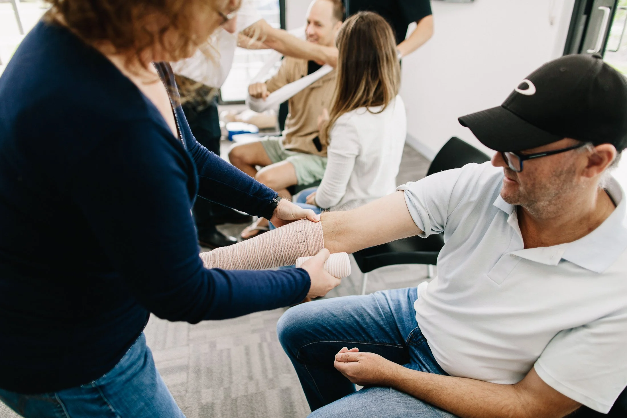 Snake bite bandage being applied to a mans arm, practicing first aid.