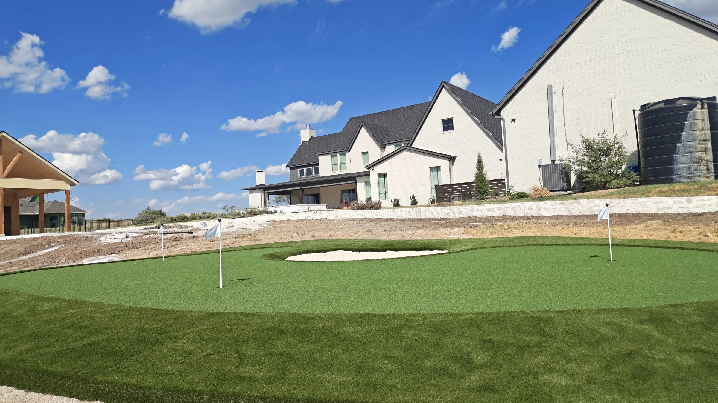 Custom backyard putting green with flag and fringe turf in DFW