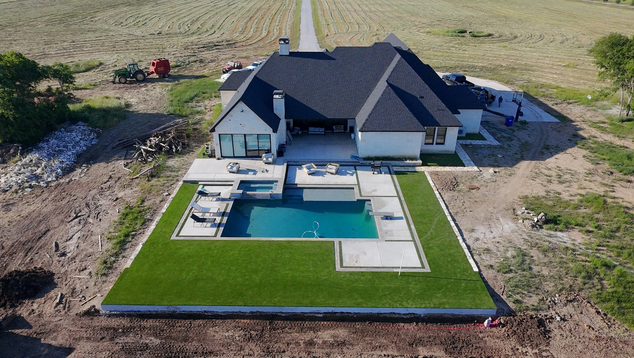 Professional artificial turf installation surrounding a luxury backyard swimming pool in Dallas-Fort Worth, featuring clean lines and a modern patio design.