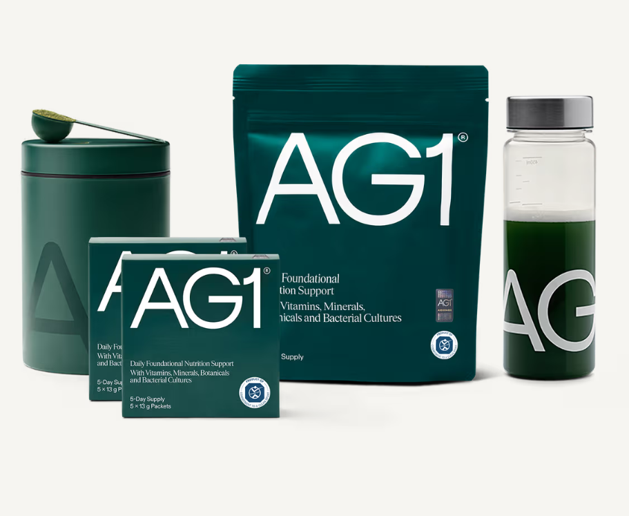 Health supplement products including AG1 foundational nutrition support packets, a large AG1 pouch, a green shaker bottle with liquid, and a green container with a scoop on top.