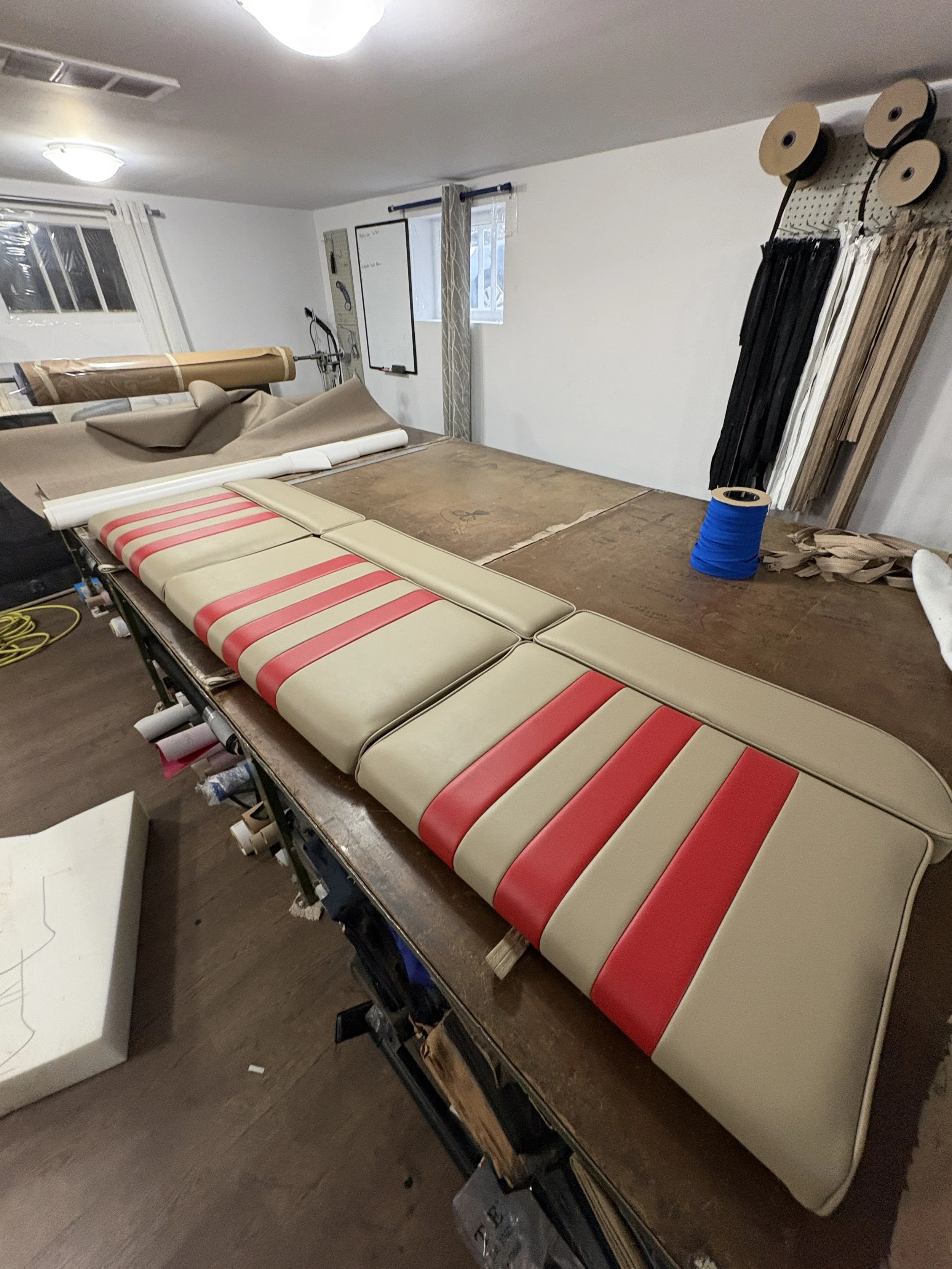 Unfinished upholstery project with foam cushions and fabric in a workshop or studio.