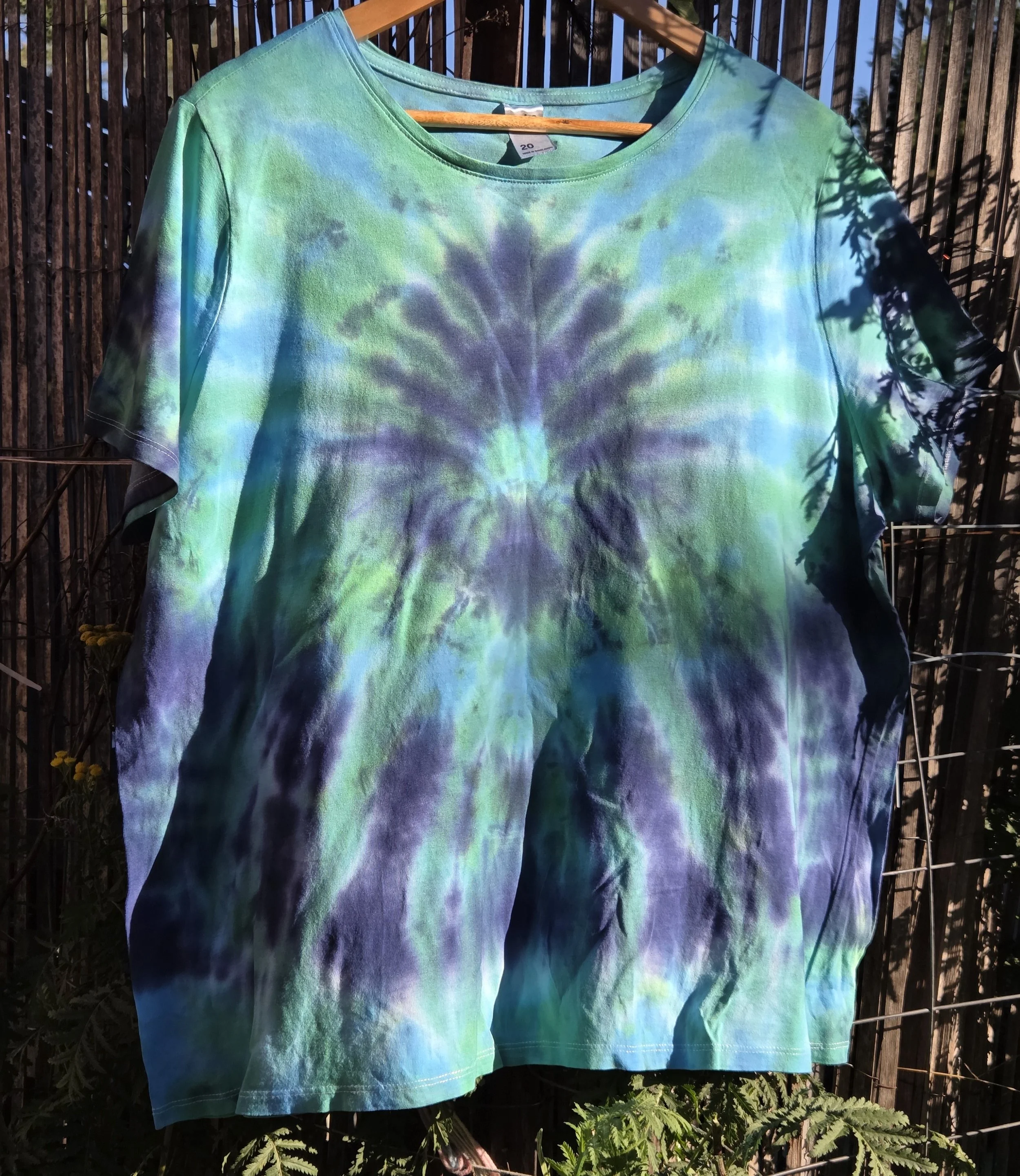 Size 20 adult hand-dyed t-shirt with a dark blue burst and spray pattern over pastel aquamarine. OOAK wearable art by Livity Studio."