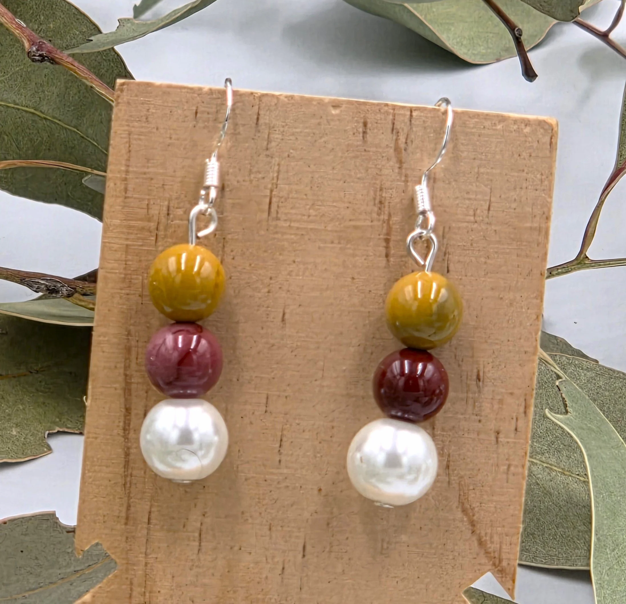 Brown and tan Mookaite beads topped with a white glass pearl on sterling silver dangle earring hooks.