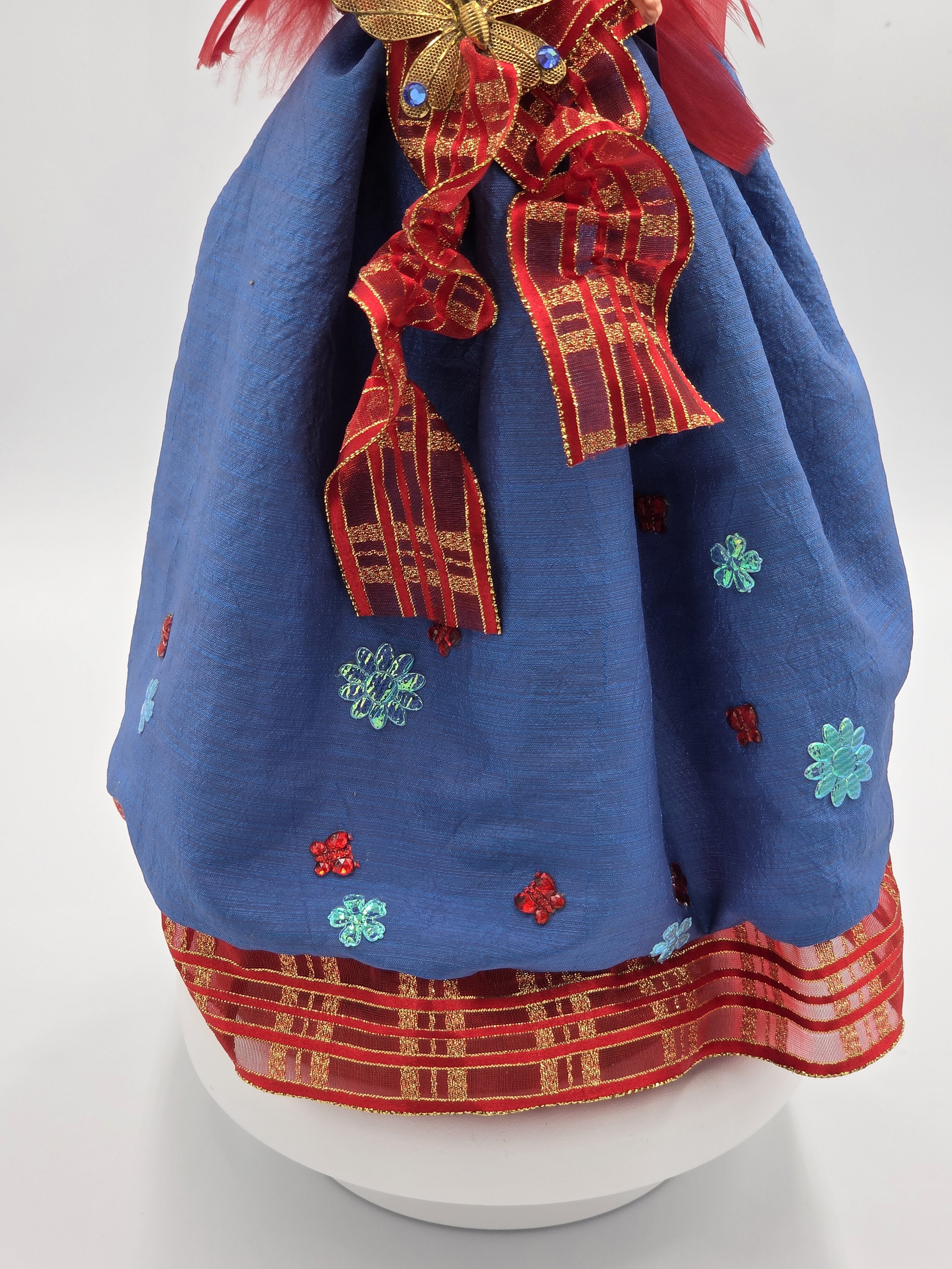 Red and blue flowers spilling down the front of the sea-blue gown.