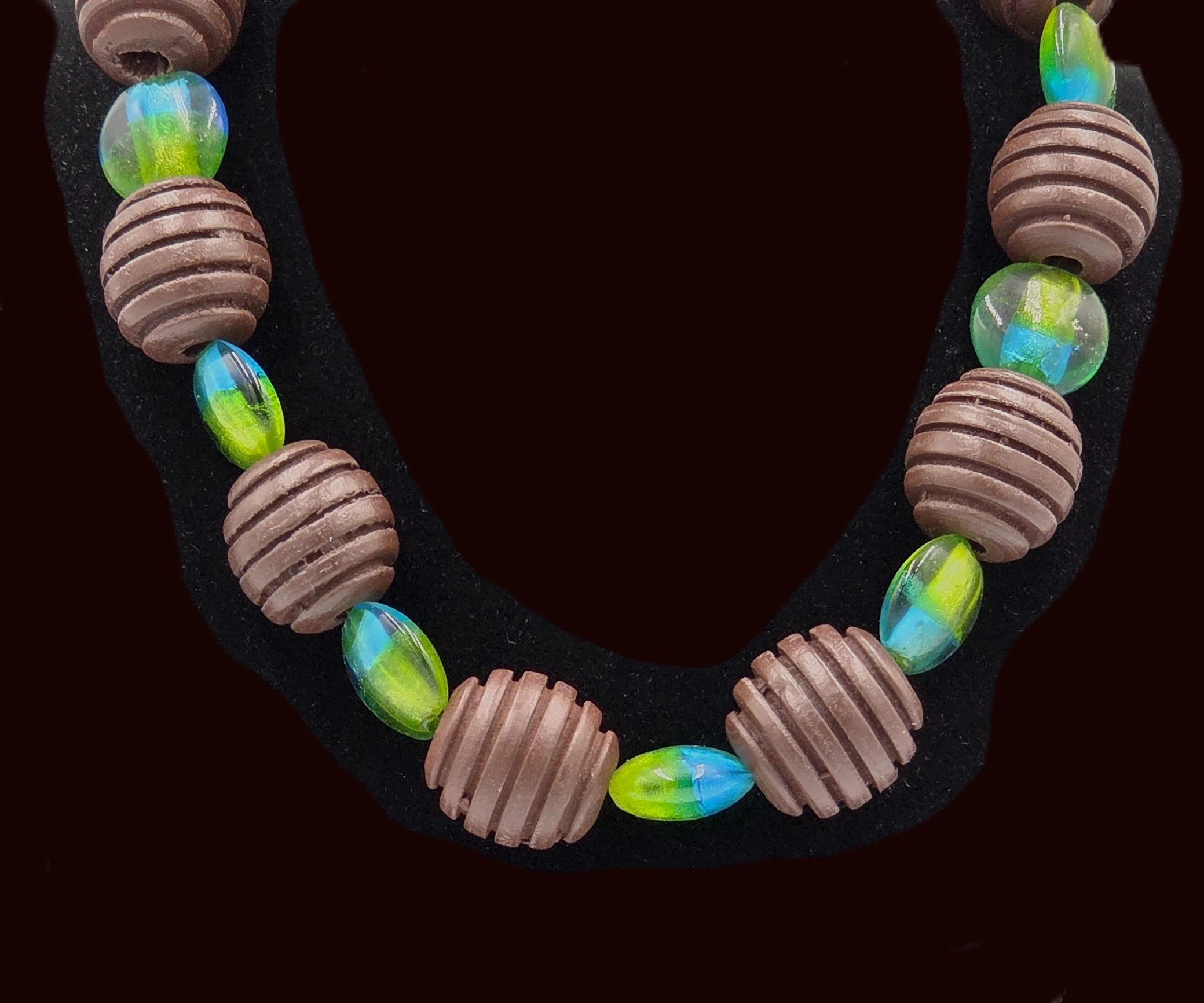 Choker necklace with large ribbed brown wood beads and blue-green foil glass beads.