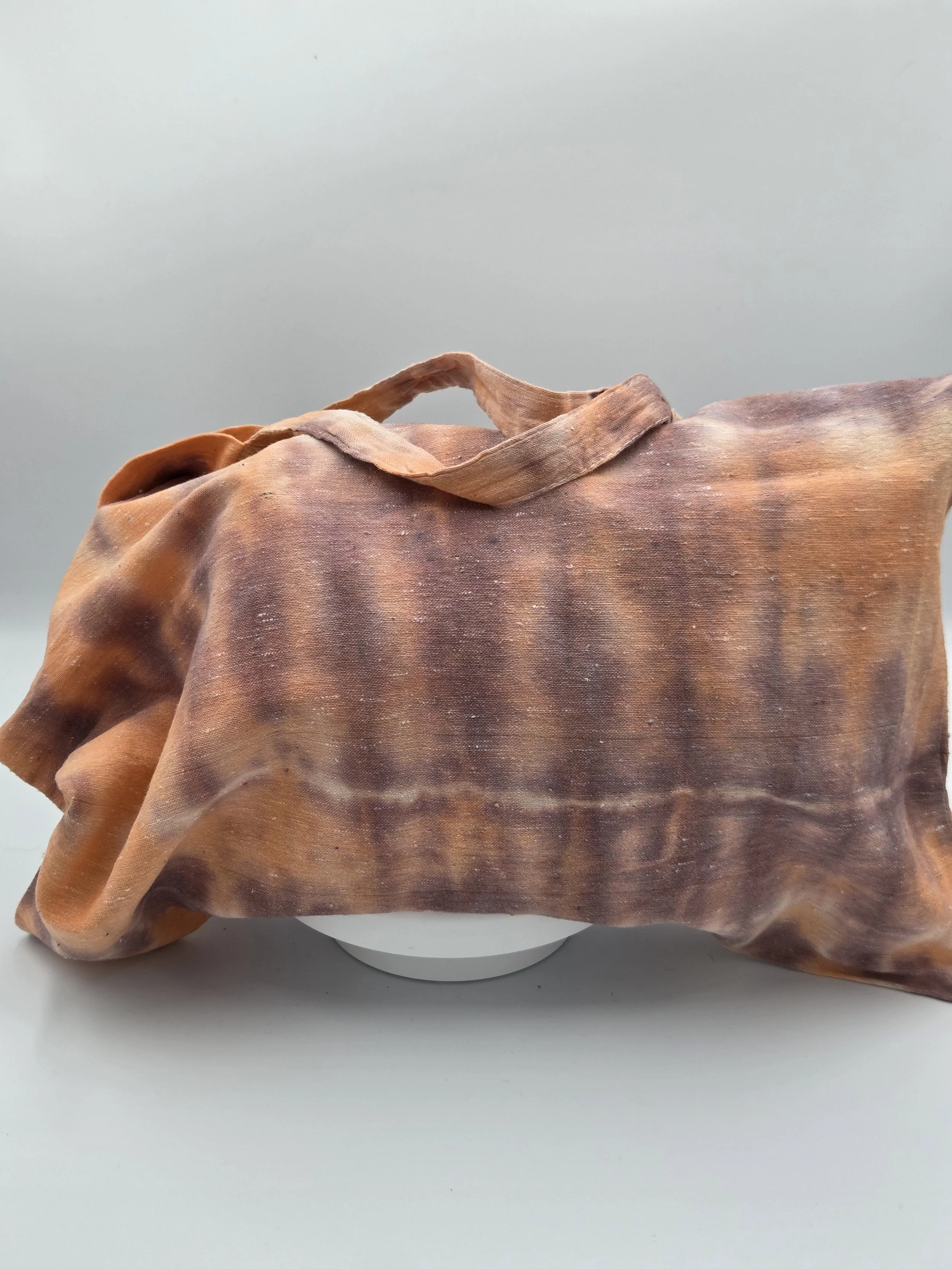 Hand-dyed calico cotton tote bag with a faded horizontal rainfall pattern in light brown and pastel orange. OOAK textile art by Livity Studio.