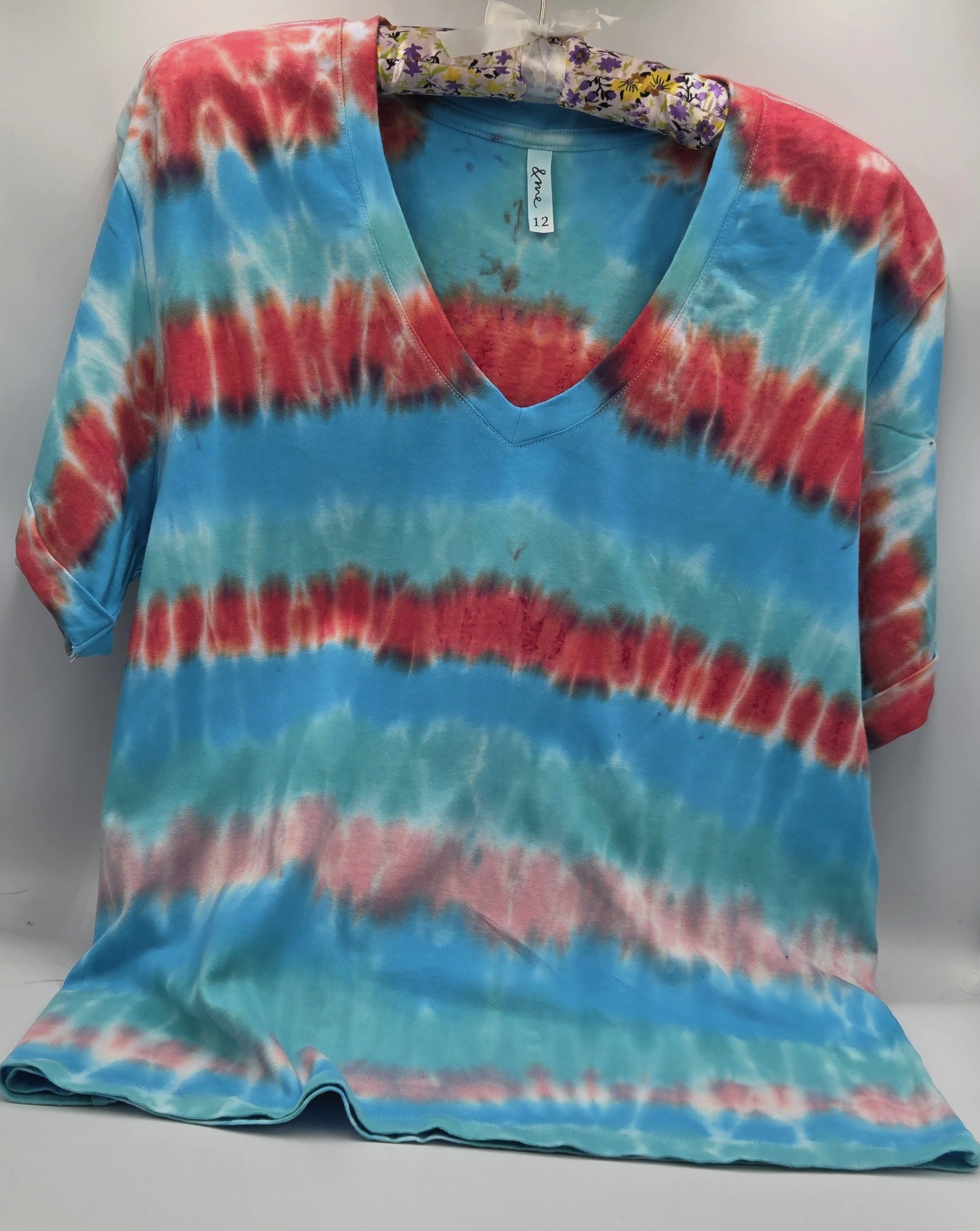An adult size 12 women's V-neck cotton t-shirt with horizontal tie-dye stripes in coral, pink, turquoise, and Aegean green