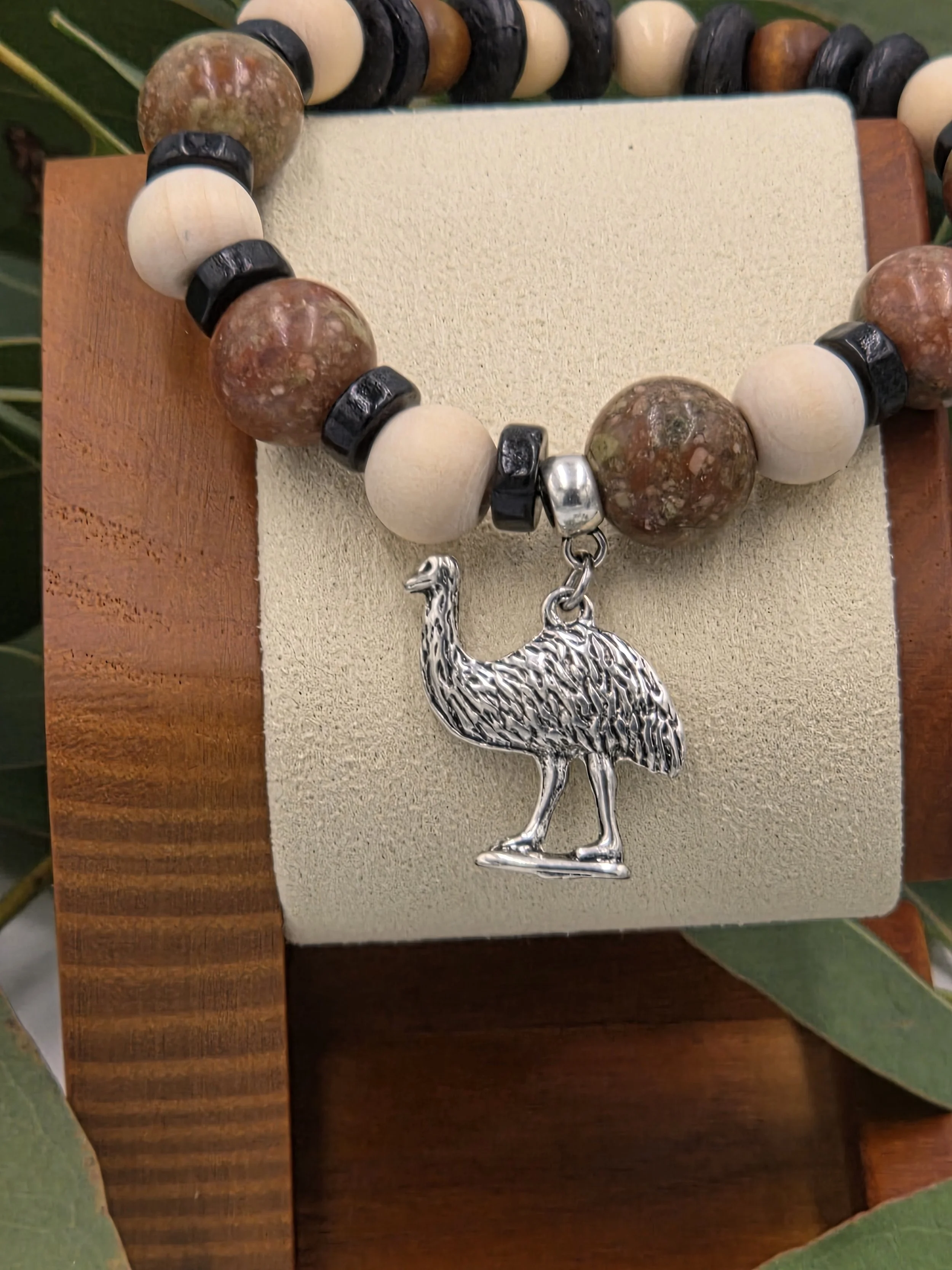 Close-up of Savannah Wanderer bracelet on wooden stand showing Jasper stone patterns.