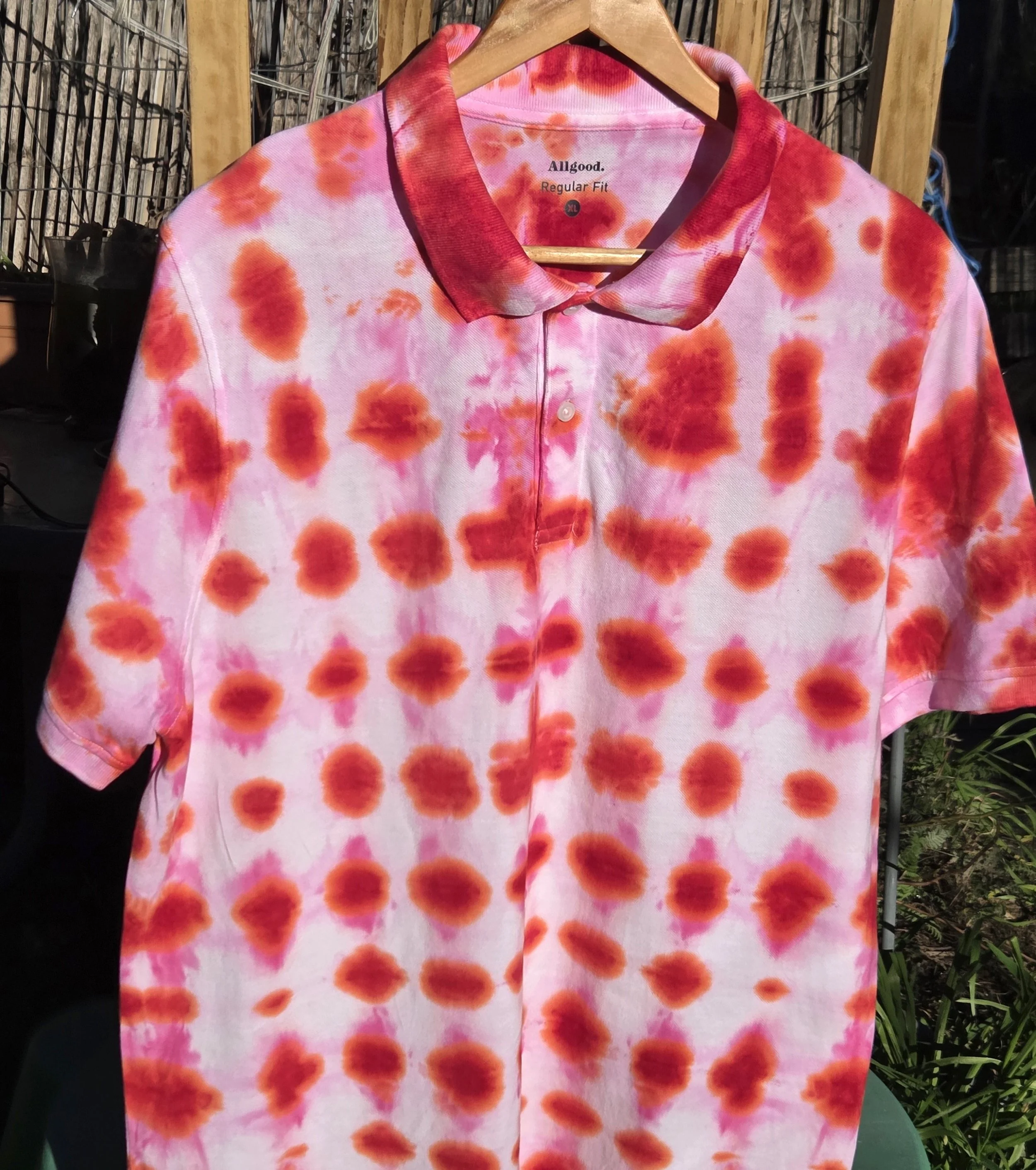 An adult size XL cotton polo shirt featuring a red tie-dye waffle weave pattern with lighter red bleeding into white negative space.