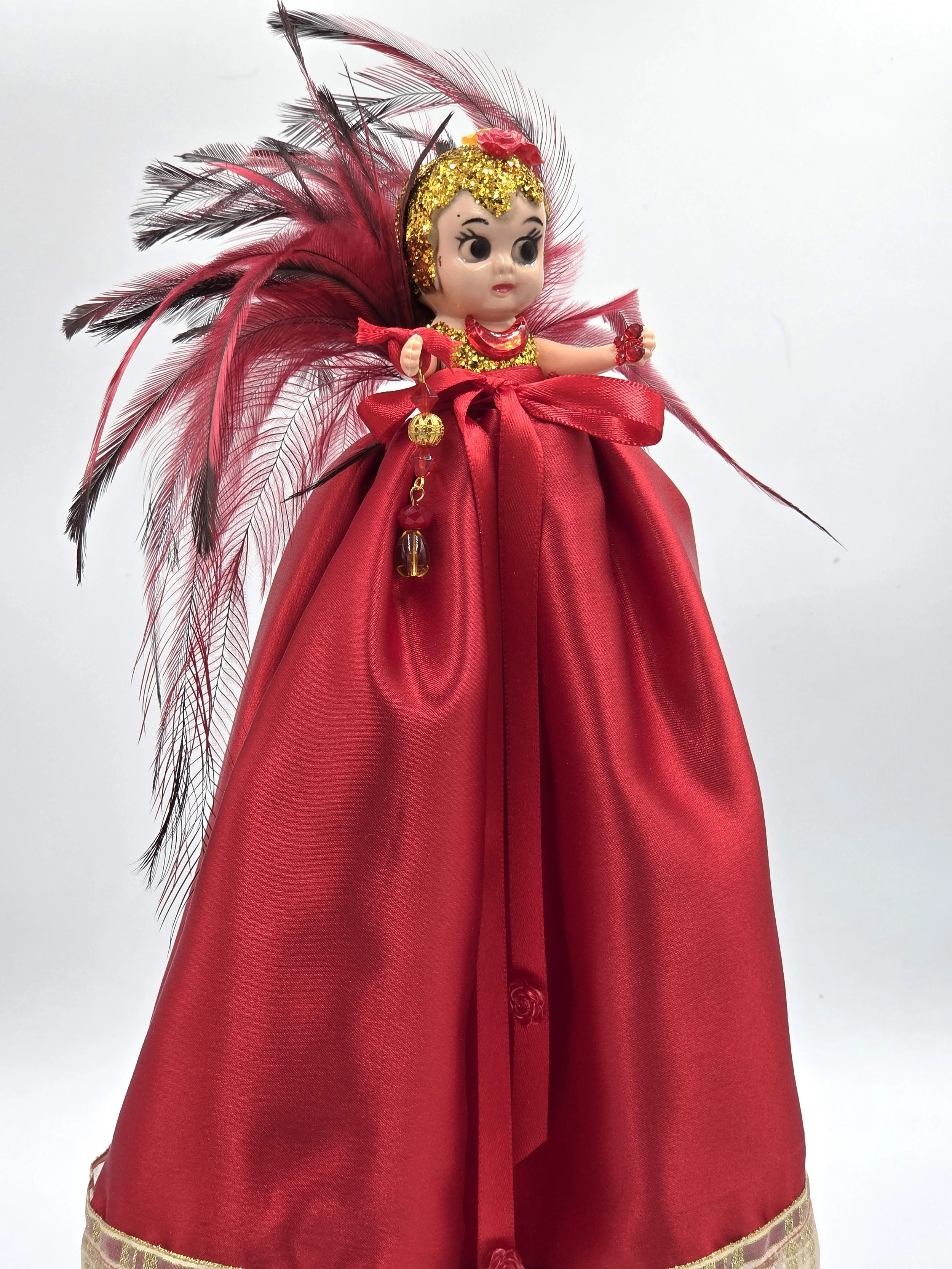 OOAK 33cm red satin art doll with a dramatic red and black feather backdrop on a red wooden stand.