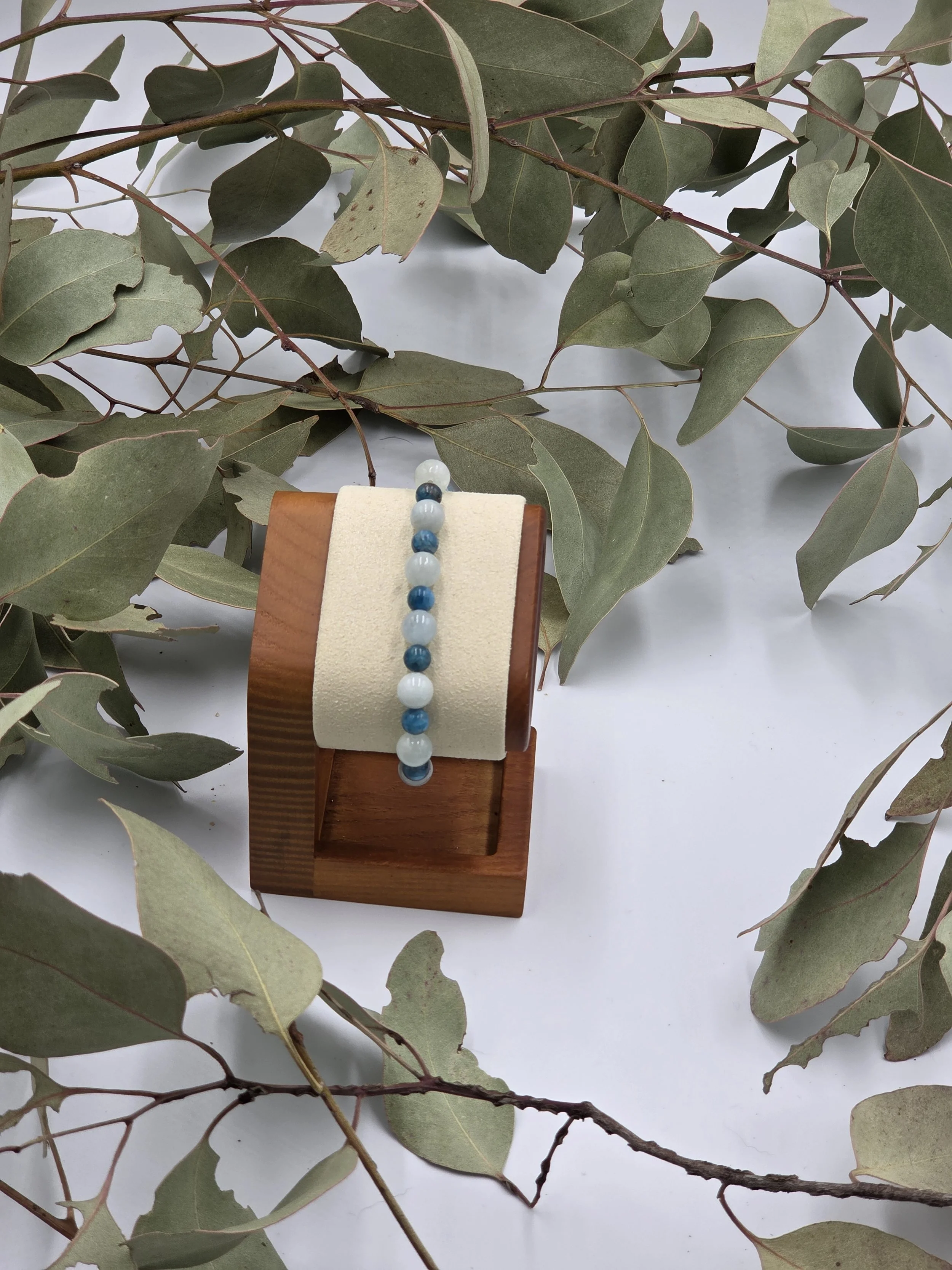 Alternating light blue-green Aquamarine beads and dark blue Apatite beads on an elastic gemstone bracelet.