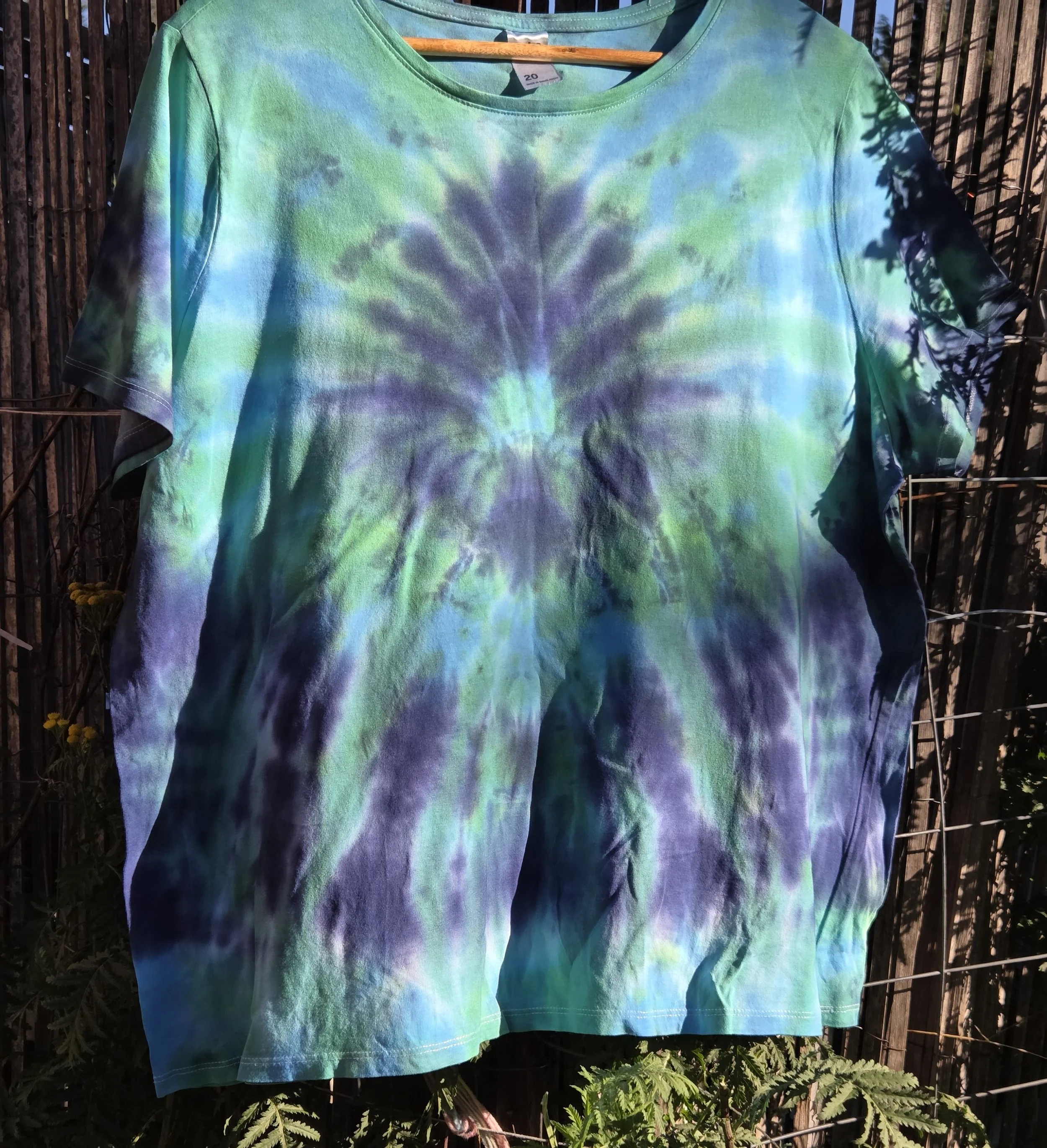 Size 20 adult hand-dyed t-shirt with a dark blue burst and spray pattern over pastel aquamarine. OOAK wearable art by Livity Studio."