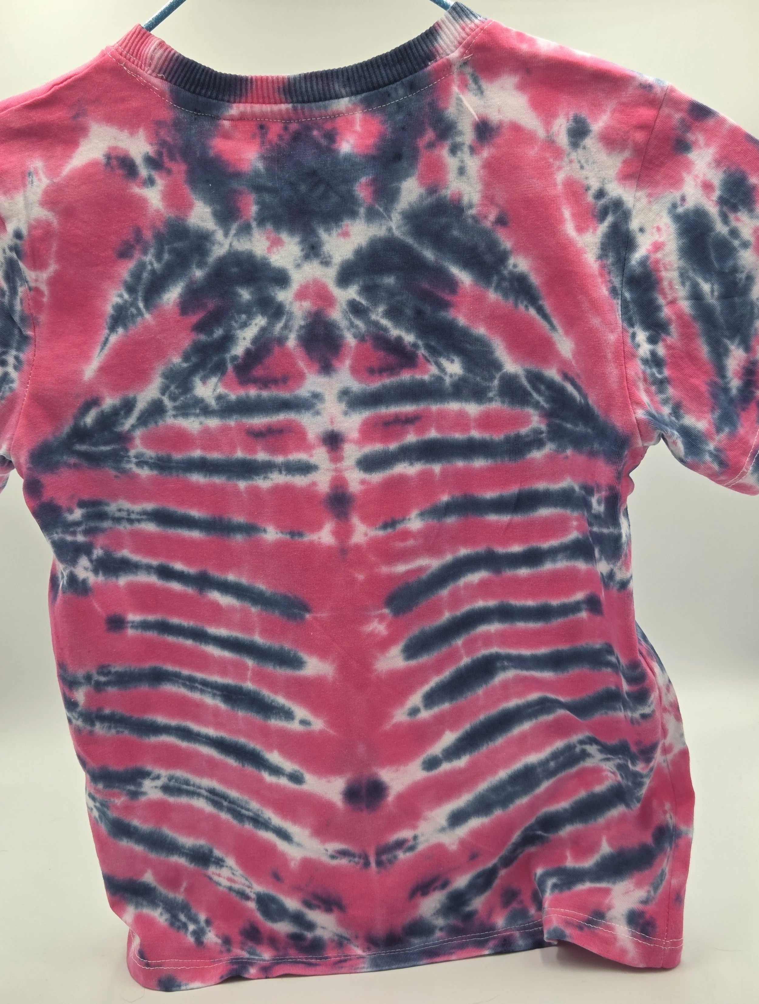 child size 7 cotton t-shirt featuring a fuchsia rib and spine tie-dye pattern against a dark blue background.