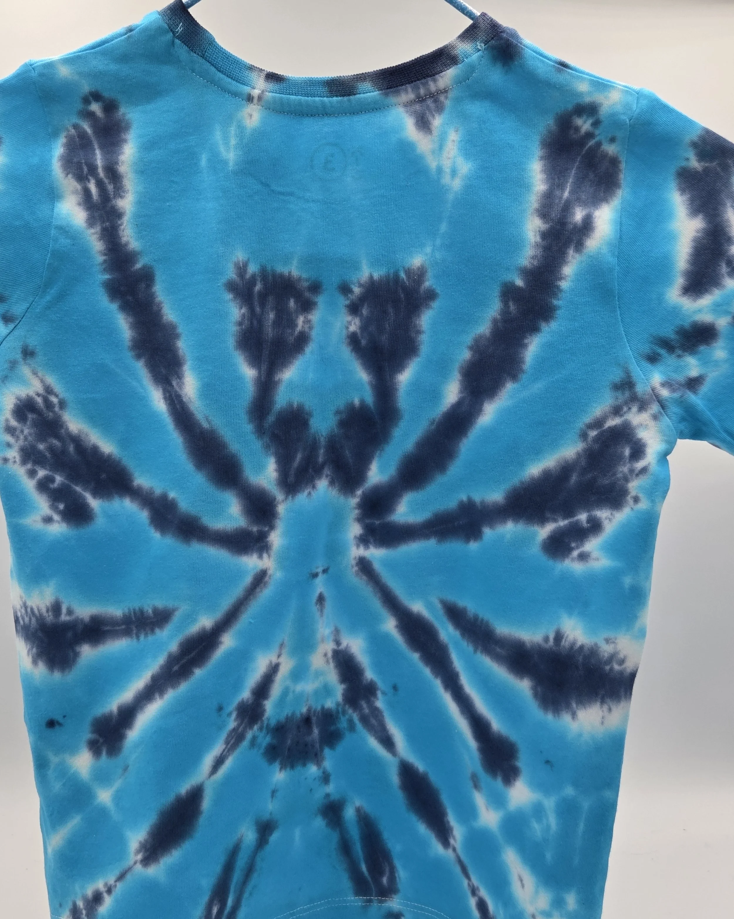 child size 3 cotton t-shirt featuring a dark blue tie-dye spider pattern against a bright turquoise background.