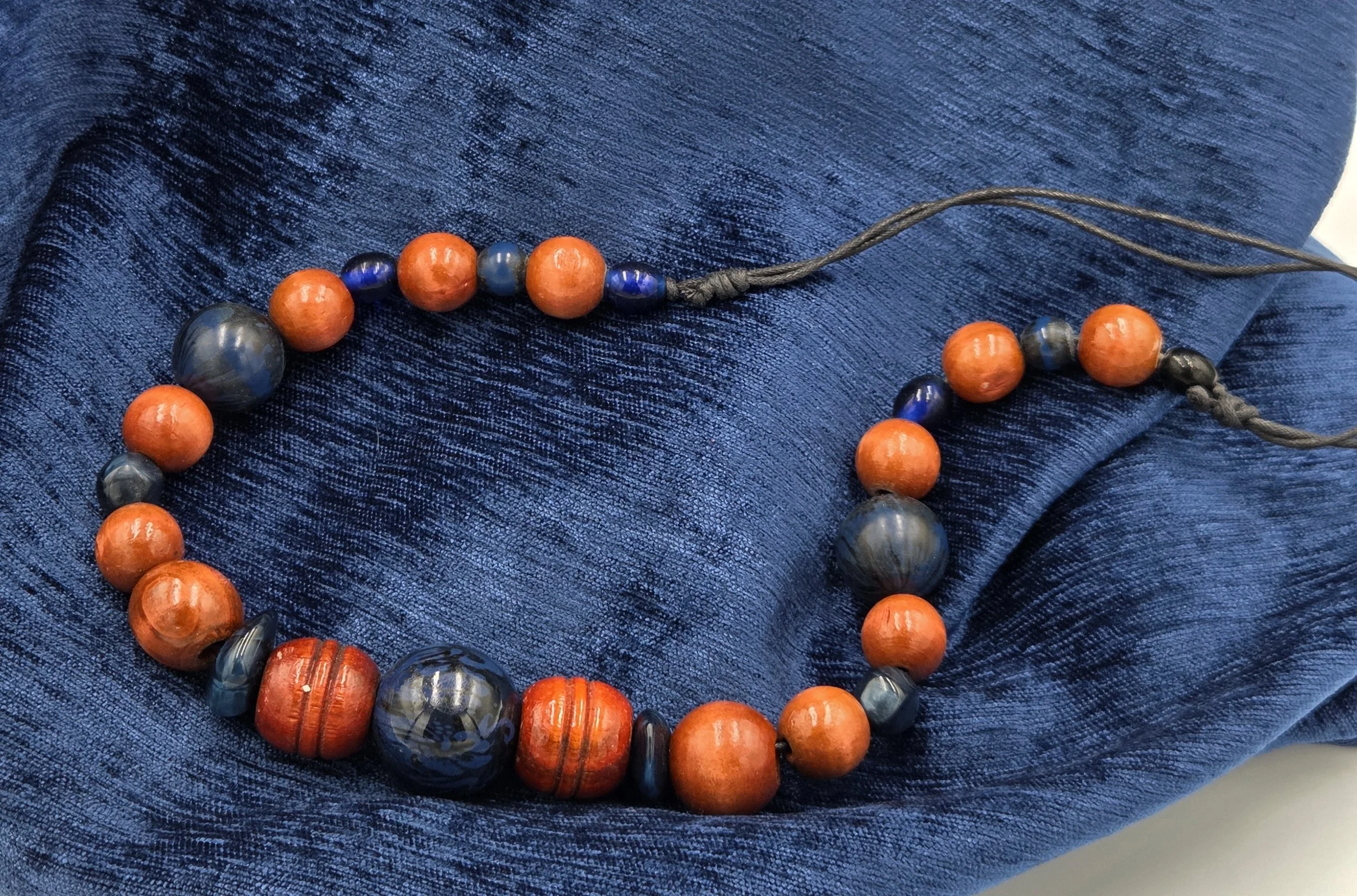 OOAK wearable sculpture featuring deep blue focal beads and large carved brown wood beads.