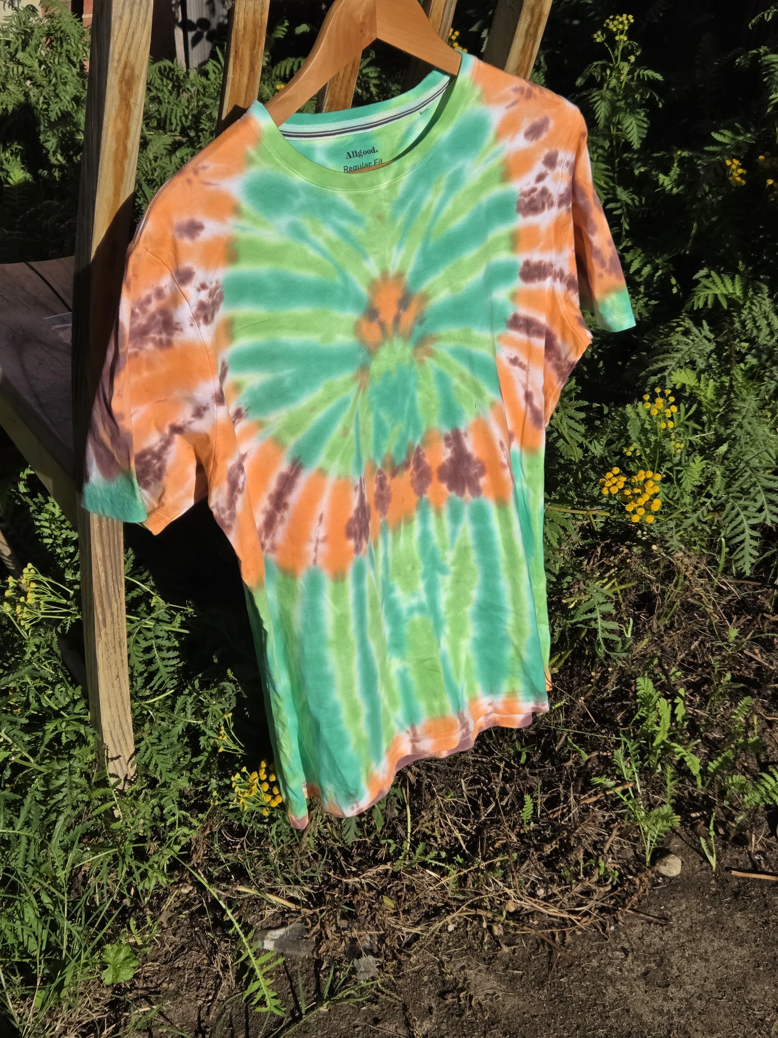 Adult Large hand-dyed green spider T-shirt with an orange and brown circular web frame. OOAK wearable art by Livity Studio Canberra."