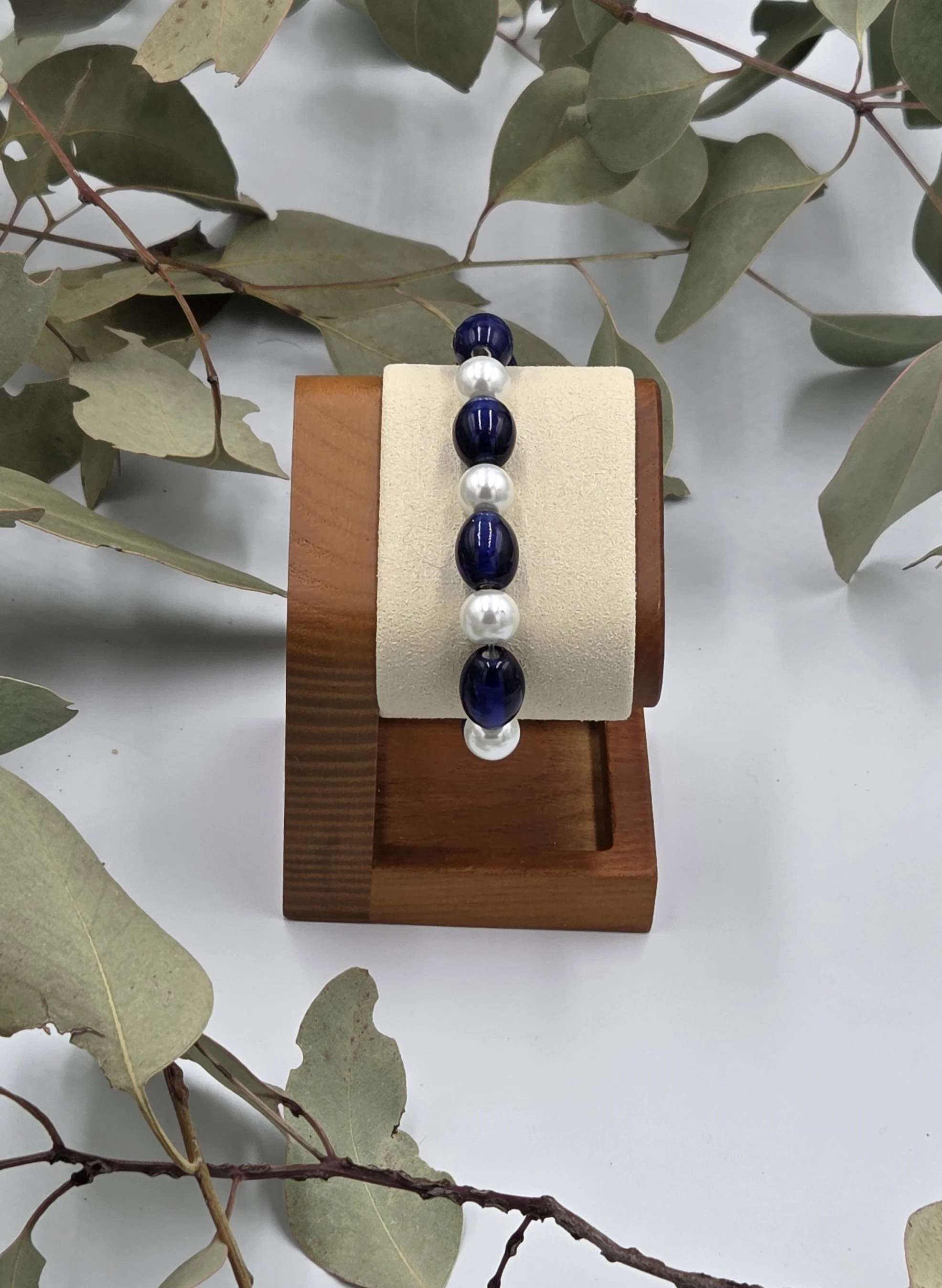 Glossy dark blue oval glass beads alternating with luminous white glass pearls on an elegant elastic bracelet.