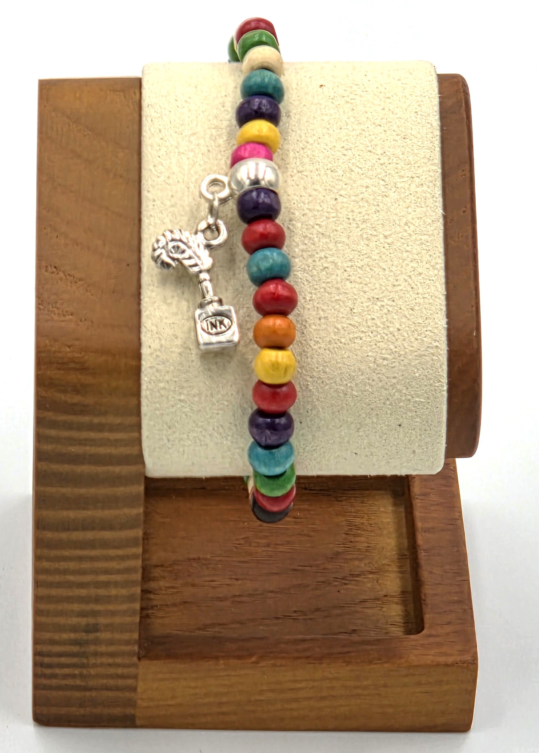 close up of OOAK multicolored wood bead bracelet with silver quill pen and ink stand charm.