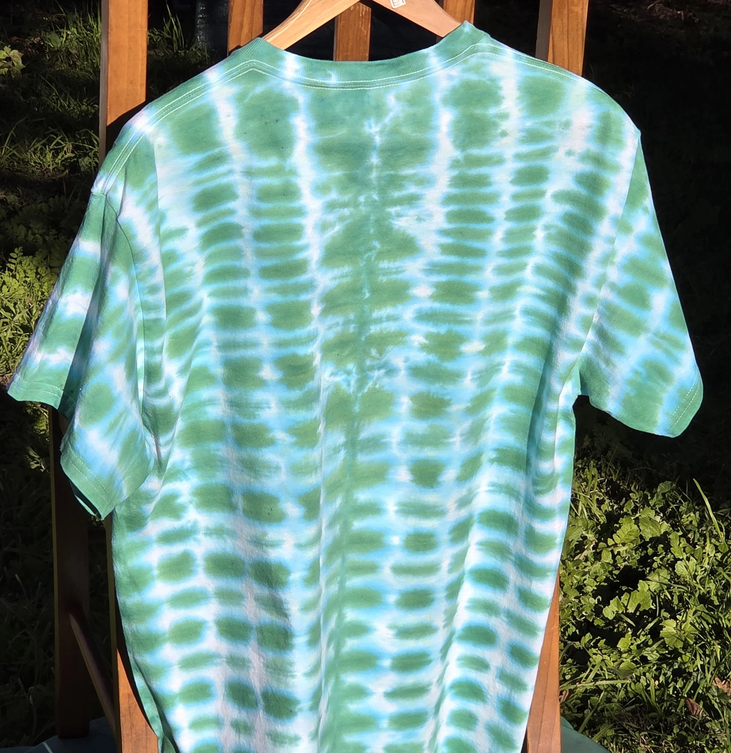 A large adult green and white t-shirt featuring a highly regular tie-dye pattern resembling green bricks in a wall.
