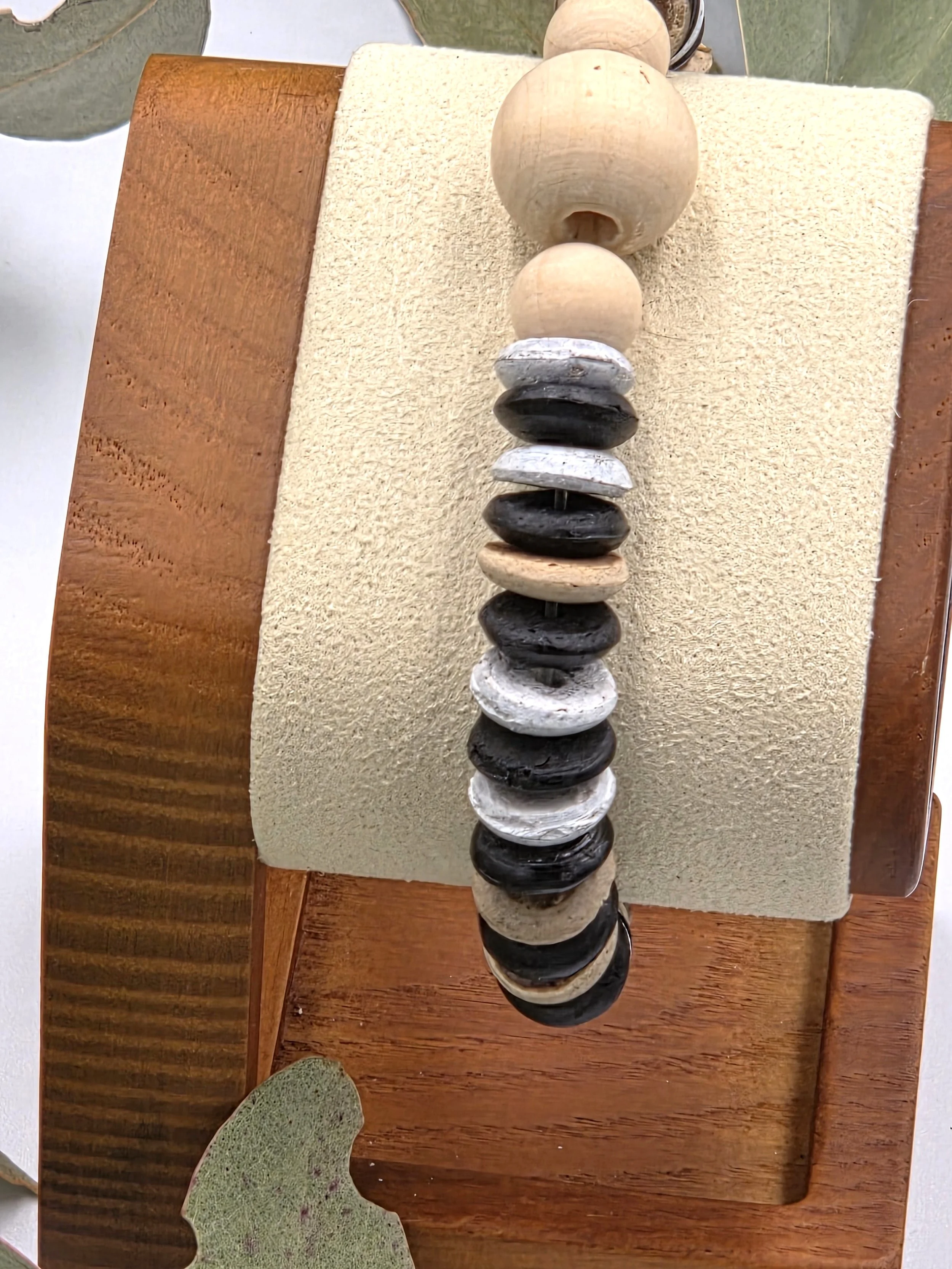 Striped brown and white coconut disc elastic bracelet featuring raw natural wood beads as a central focal point