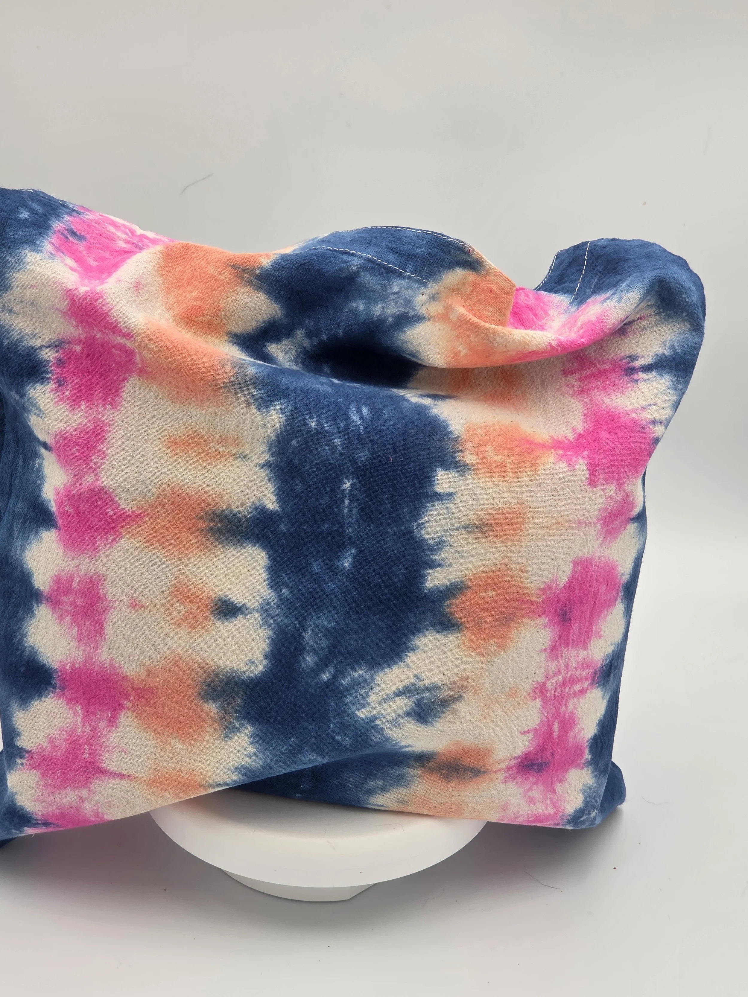 calico tote bag featuring vertical tie-dye columns of dark blue, soft pink, and pale orange with white spaces.