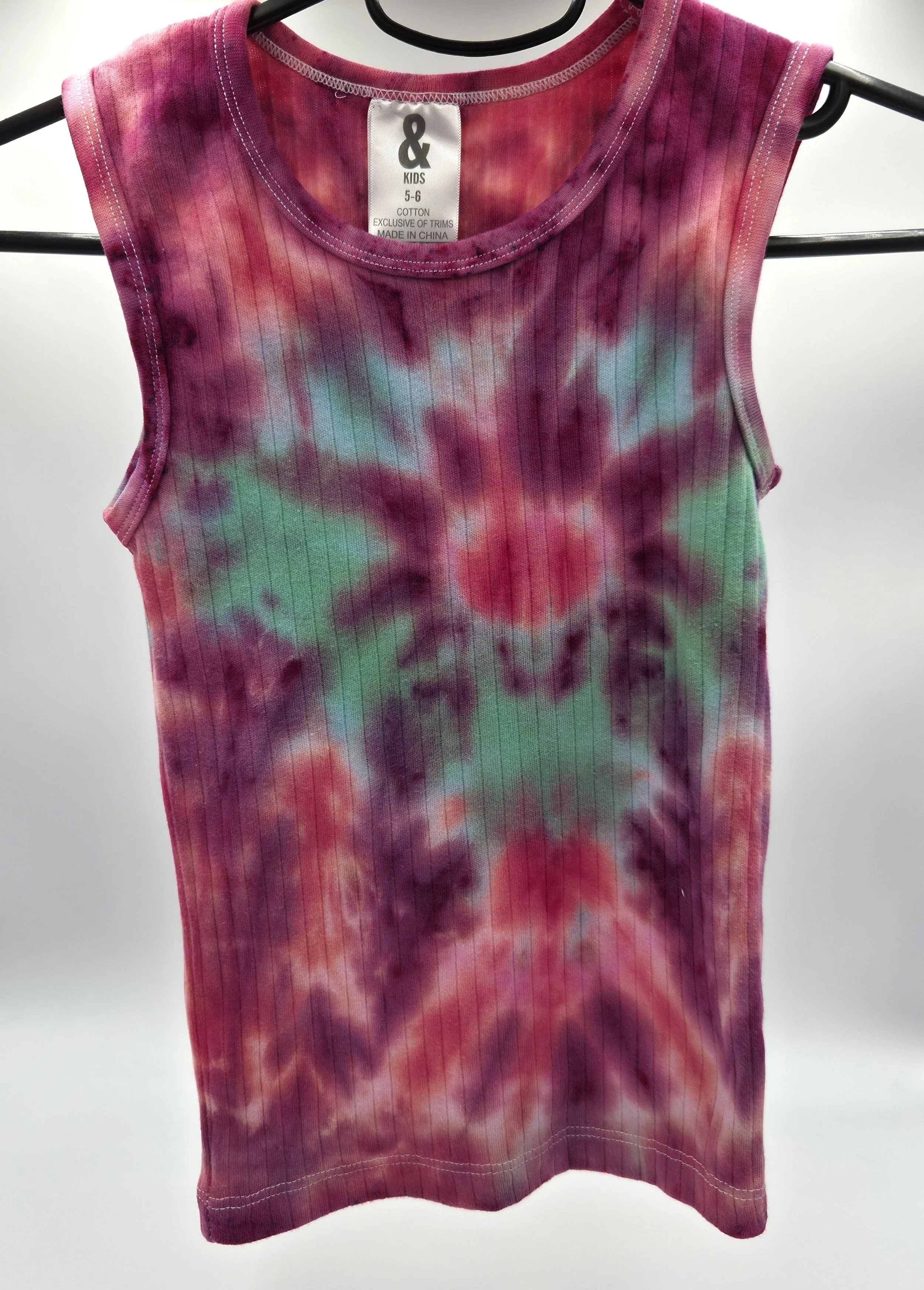 A child's ribbed singlet with a deep burgundy and red tie-dye background, featuring a central green and blue spider pattern that radiates outward.