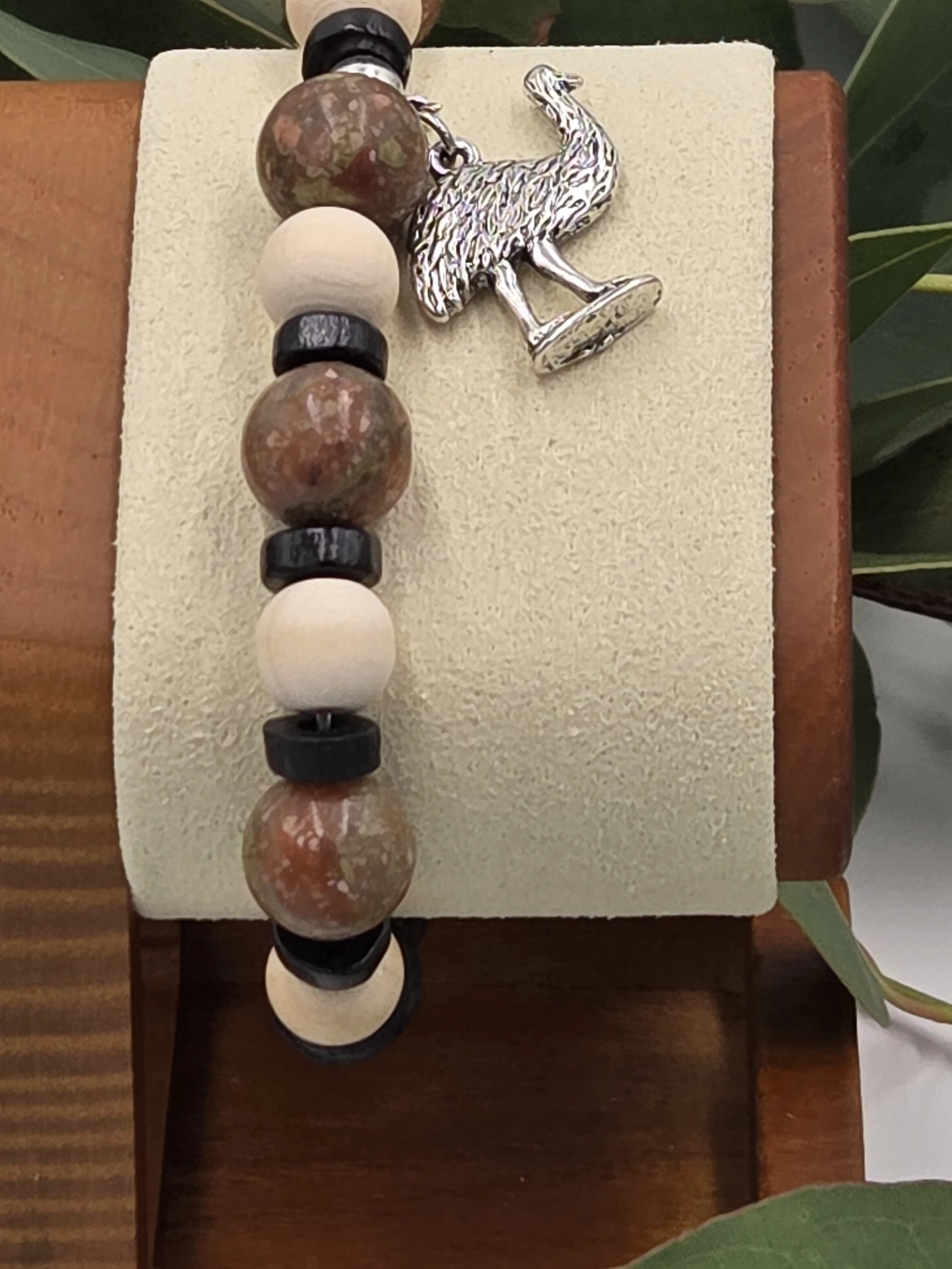 Close-up of Savannah Wanderer bracelet on wooden stand showing Jasper stone patterns.