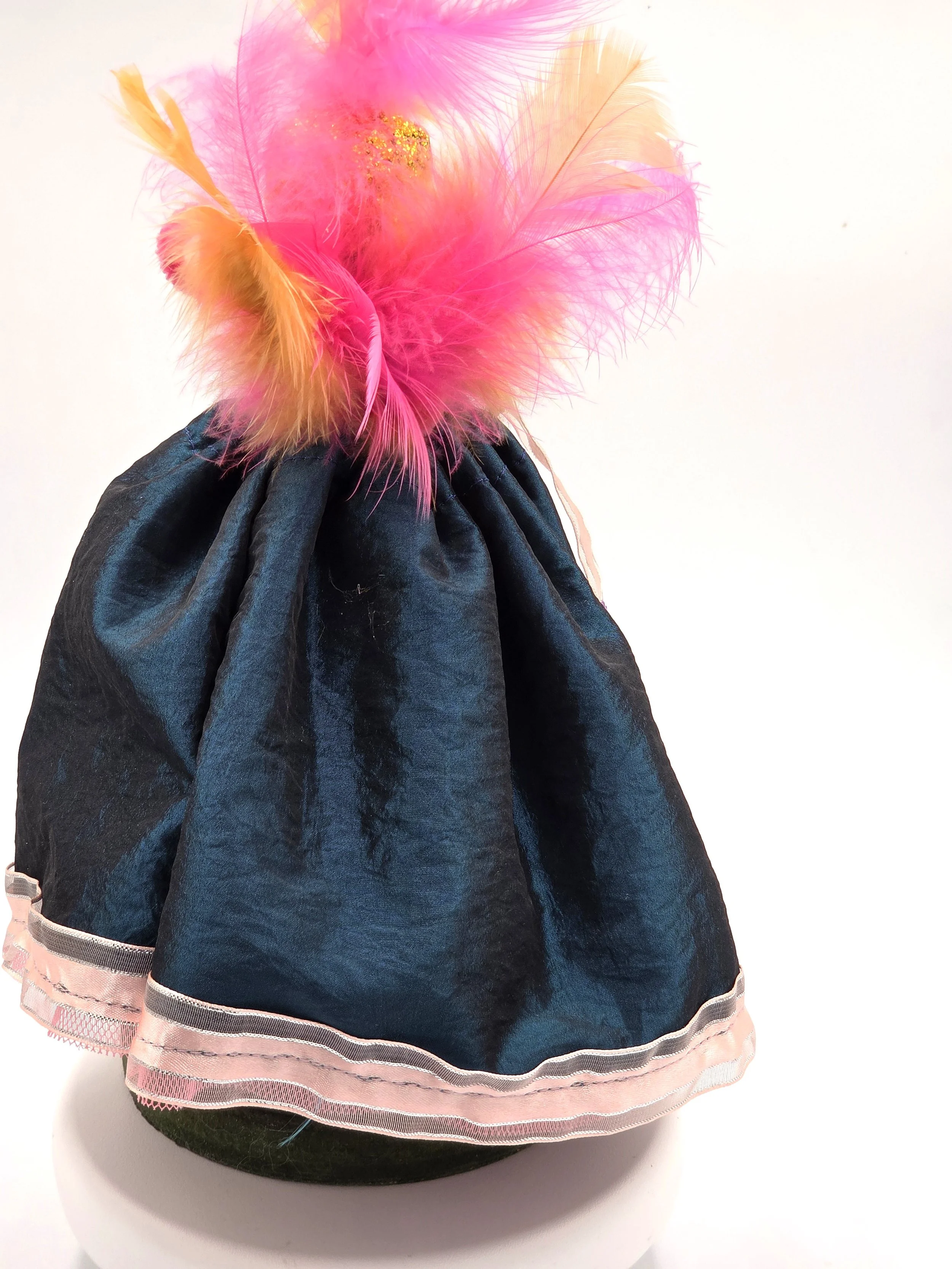 Back view Garden Sprite doll in evergreen taffeta with pink ribbon and feathers.