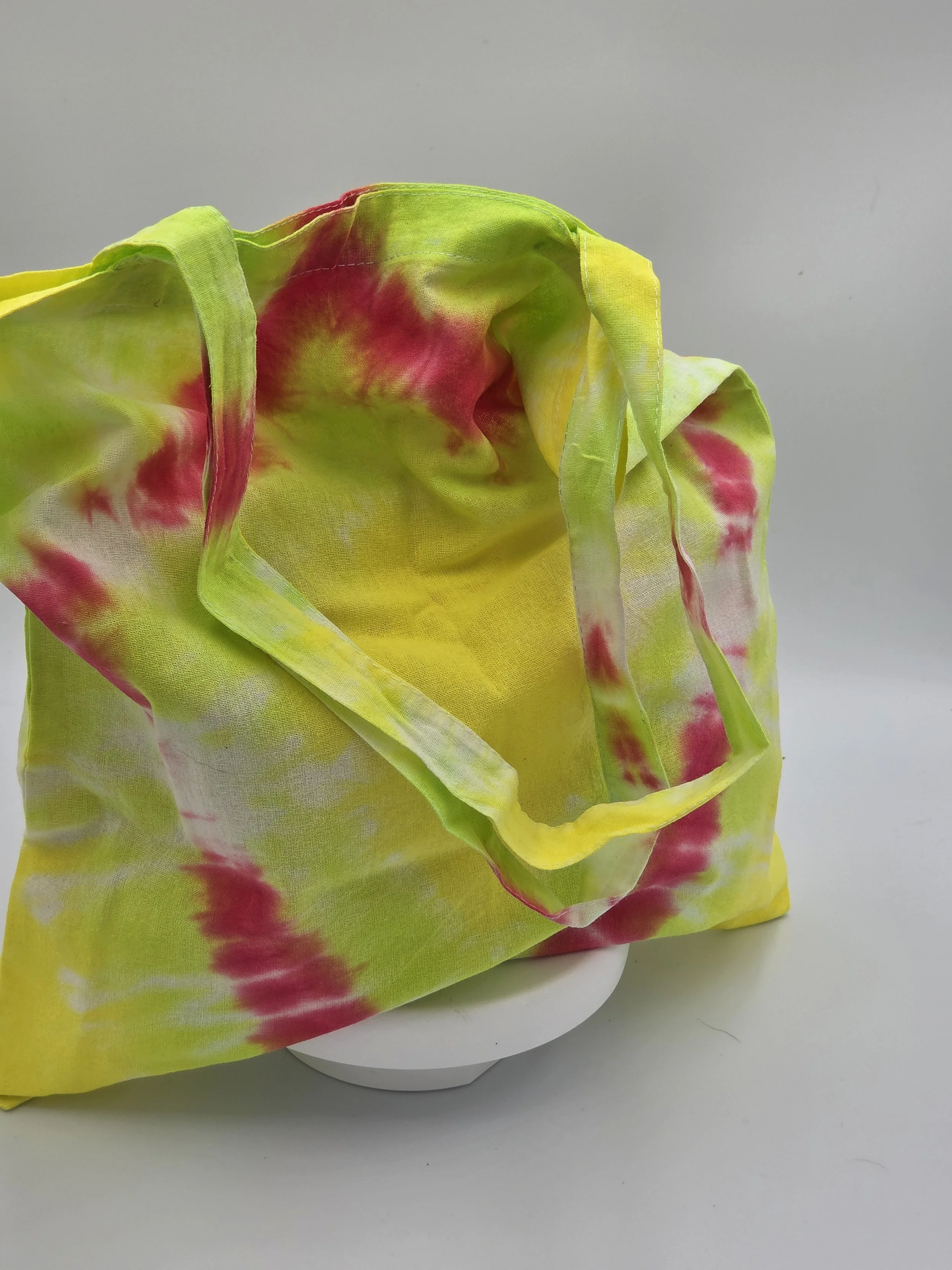 Hand-dyed cotton tote bag with a fuchsia diamond center on a lime and yellow background. OOAK textile art by Livity Studio.