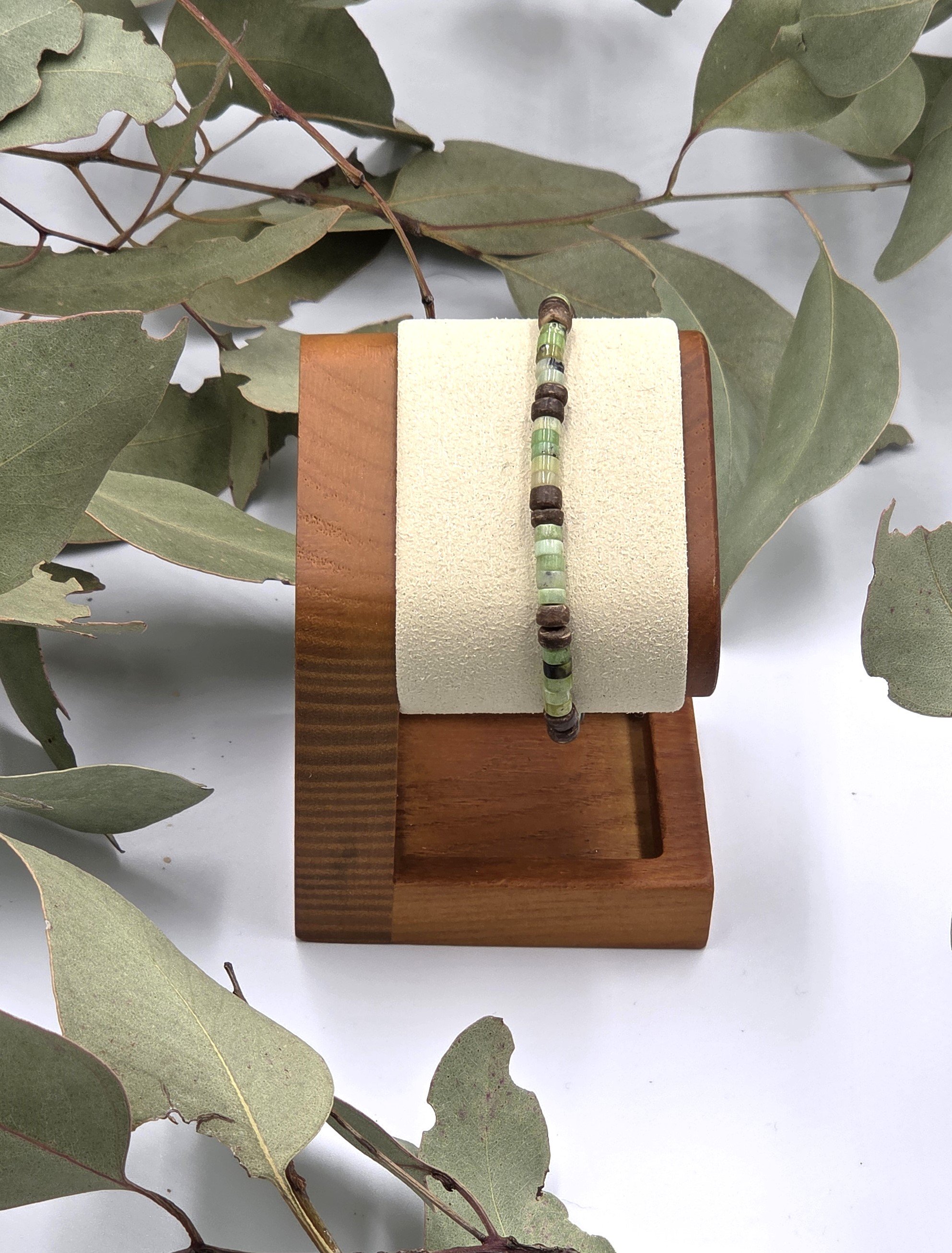 Very small green chrysoprase discs alternating in groups of five with pairs of brown coconut discs on a delicate elastic bracelet.