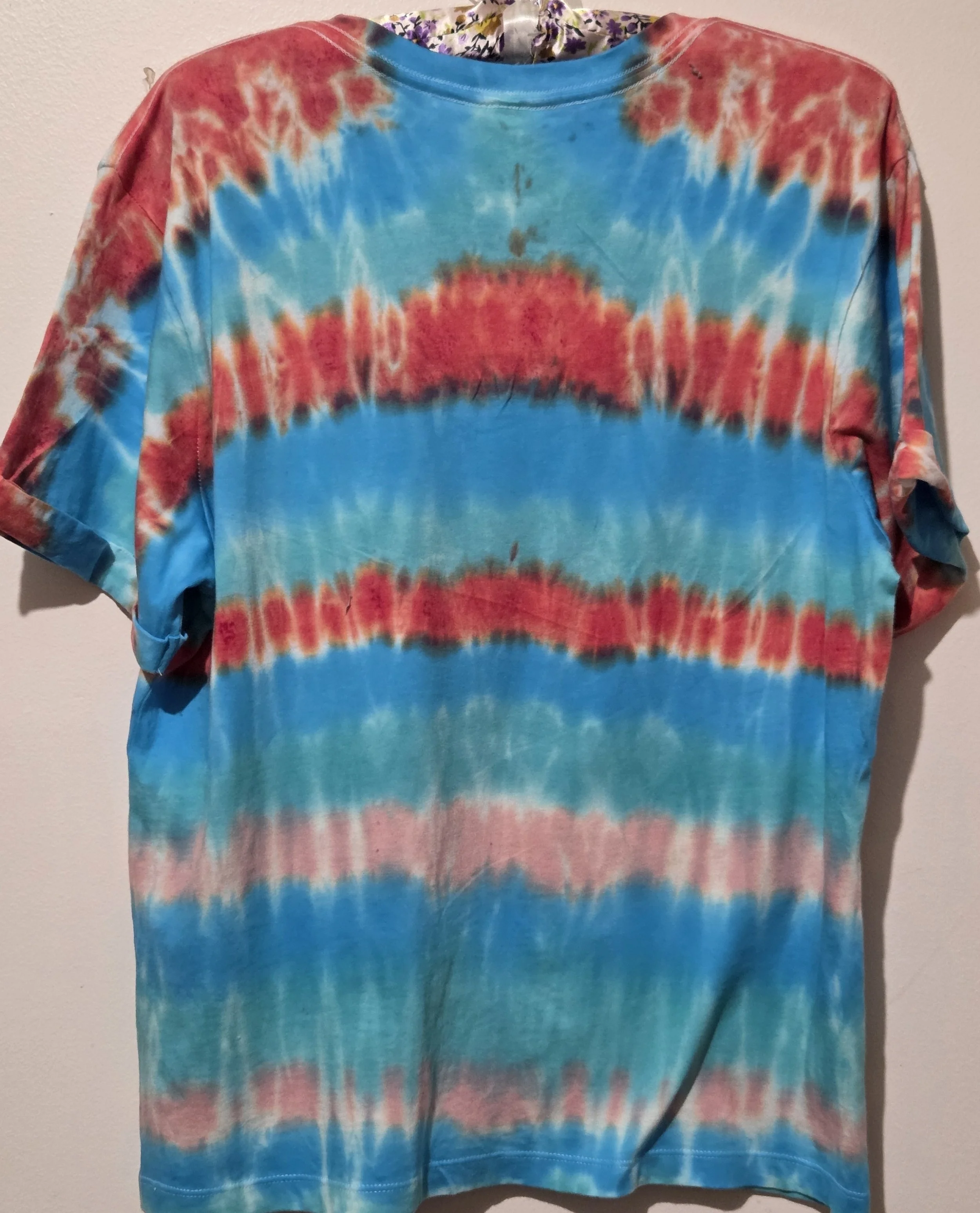 An adult size 12 women's V-neck cotton t-shirt with horizontal tie-dye stripes in coral, pink, turquoise, and Aegean green