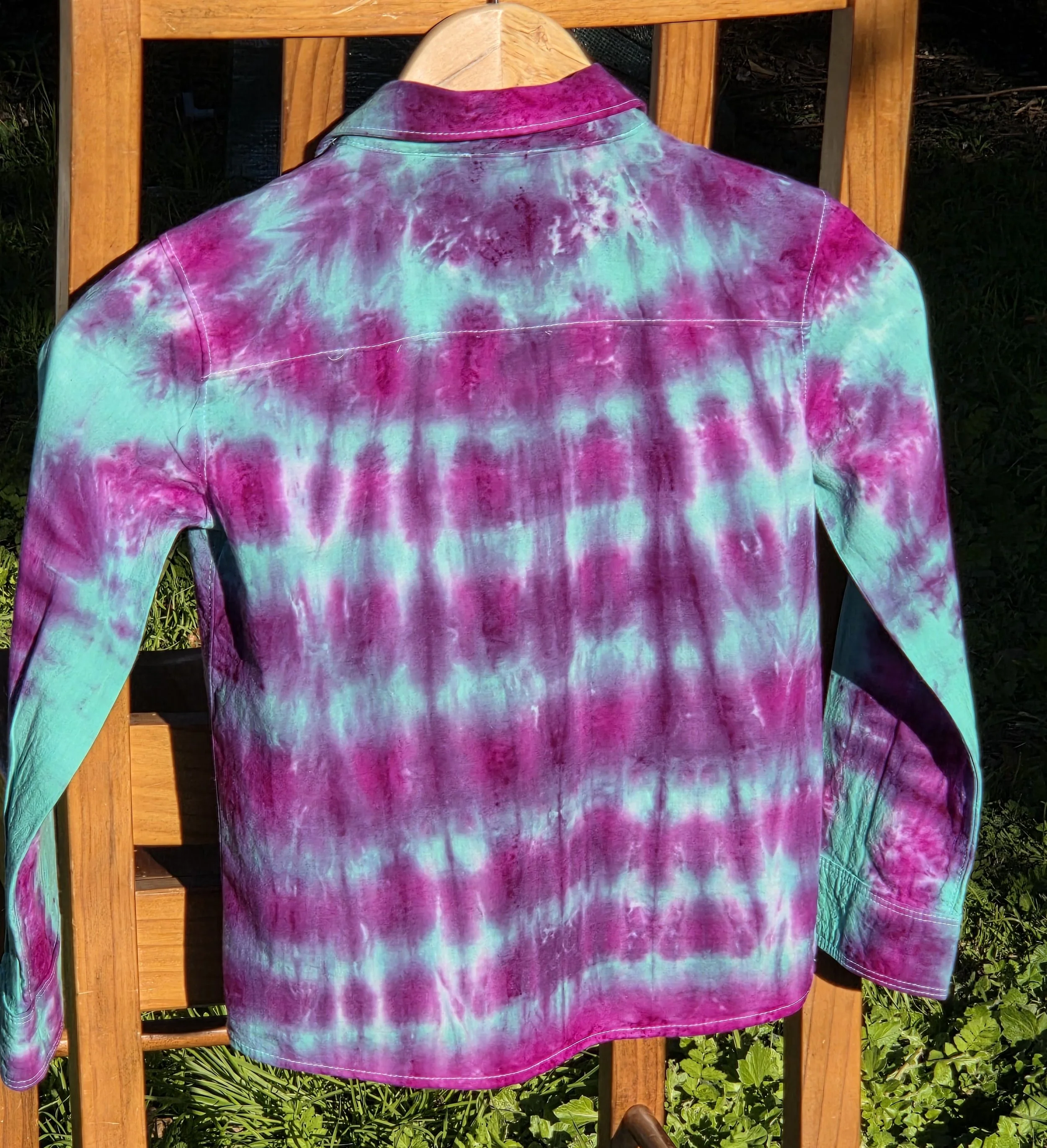 A child's size 6 long-sleeved collared shirt featuring a tie-dye pattern of consistent horizontal purple lines over a bright teal background.