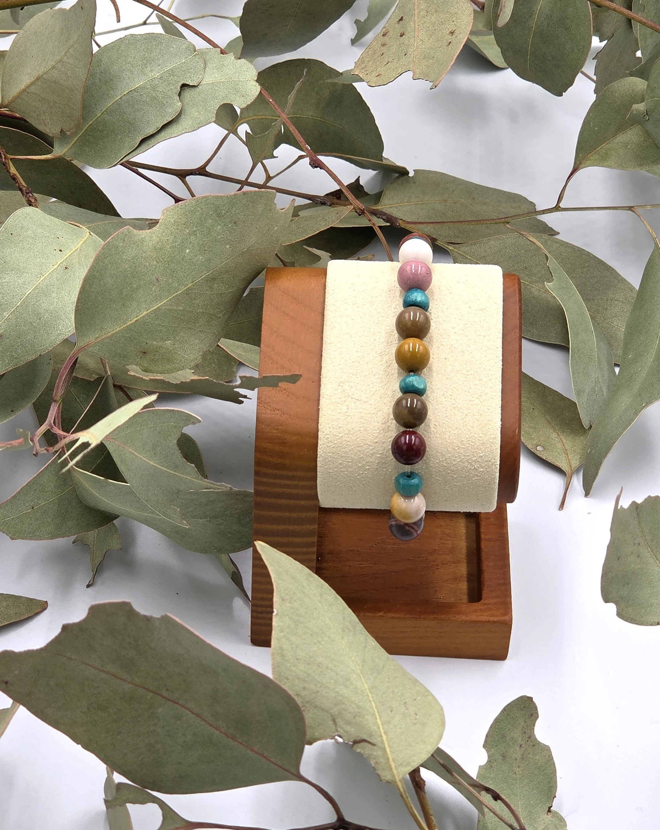 Earth-toned cream and brown Mookaite jasper beads alternating with small sky blue wood beads on an elastic bracelet.