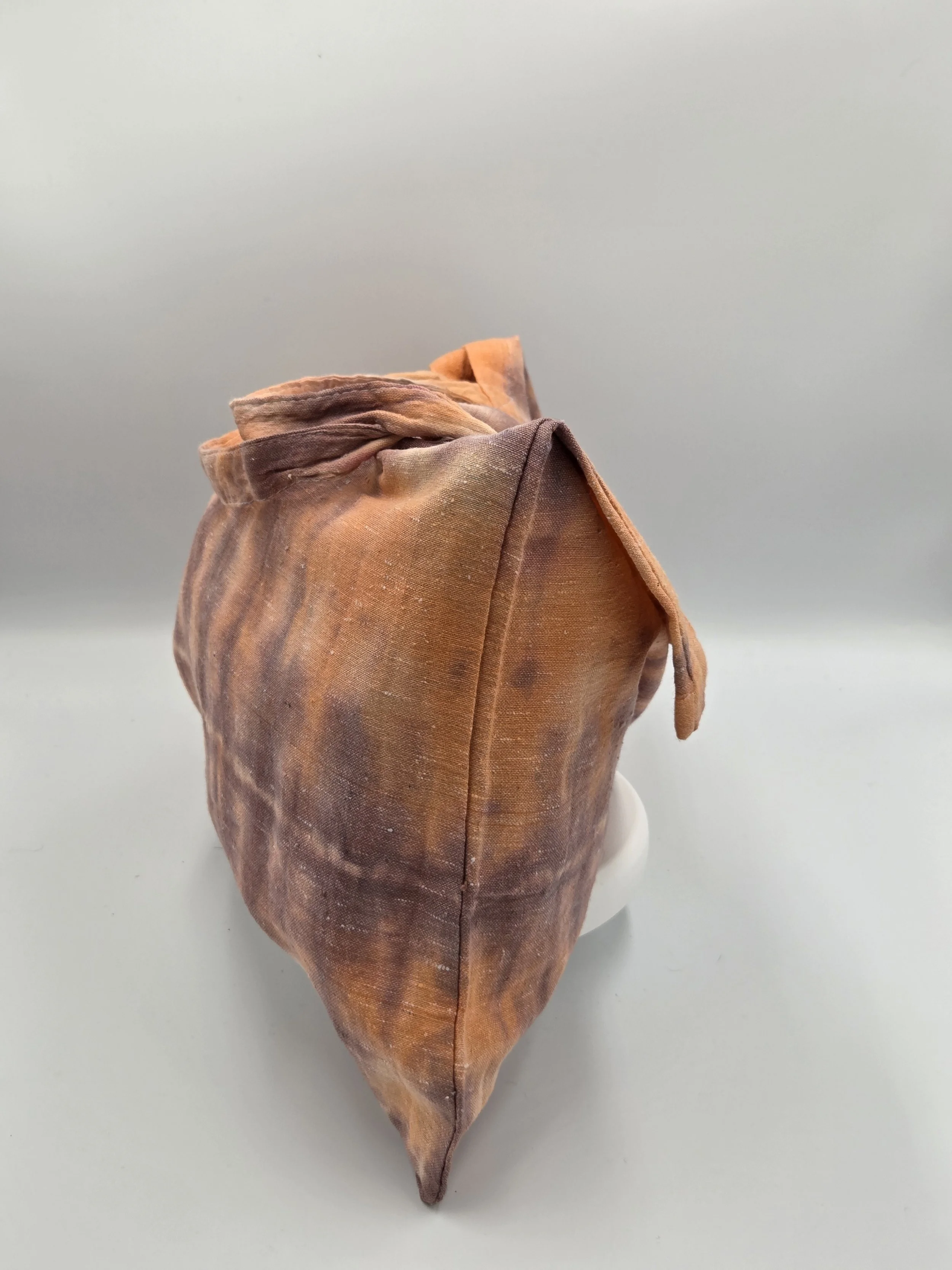 Hand-dyed calico cotton tote bag with a faded horizontal rainfall pattern in light brown and pastel orange. OOAK textile art by Livity Studio.