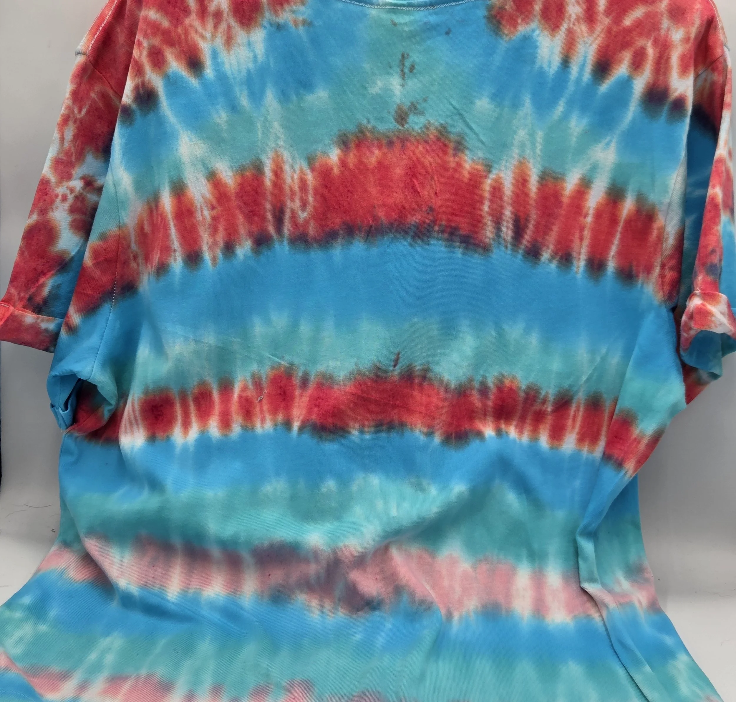 An adult size 12 women's V-neck cotton t-shirt with horizontal tie-dye stripes in coral, pink, turquoise, and Aegean green