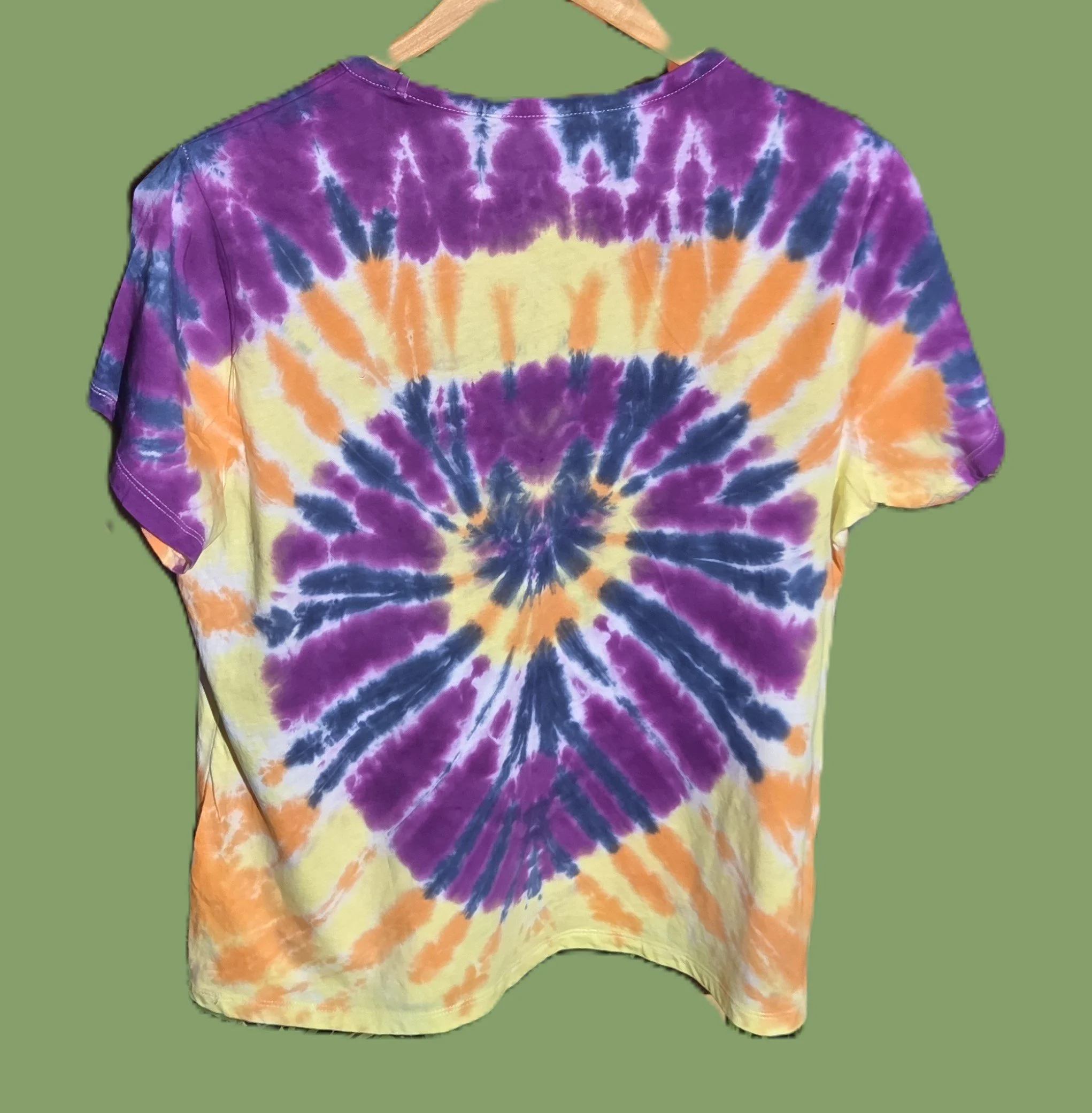 An adult size 14 women's cotton t-shirt featuring a tie-dye sunburst design in purple, dark blue, yellow, and orange.