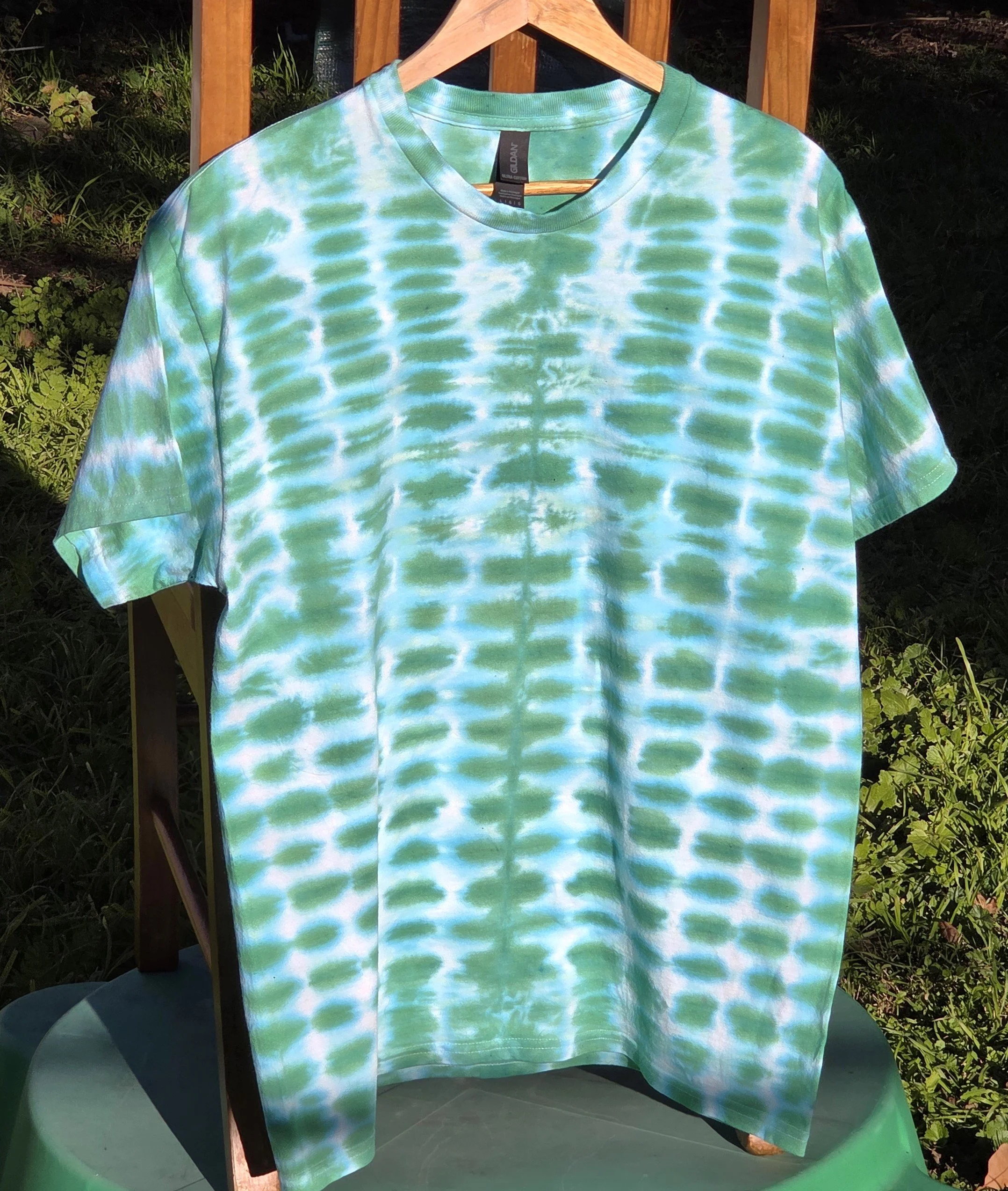 A large adult green and white t-shirt featuring a highly regular tie-dye pattern resembling green bricks in a wall.