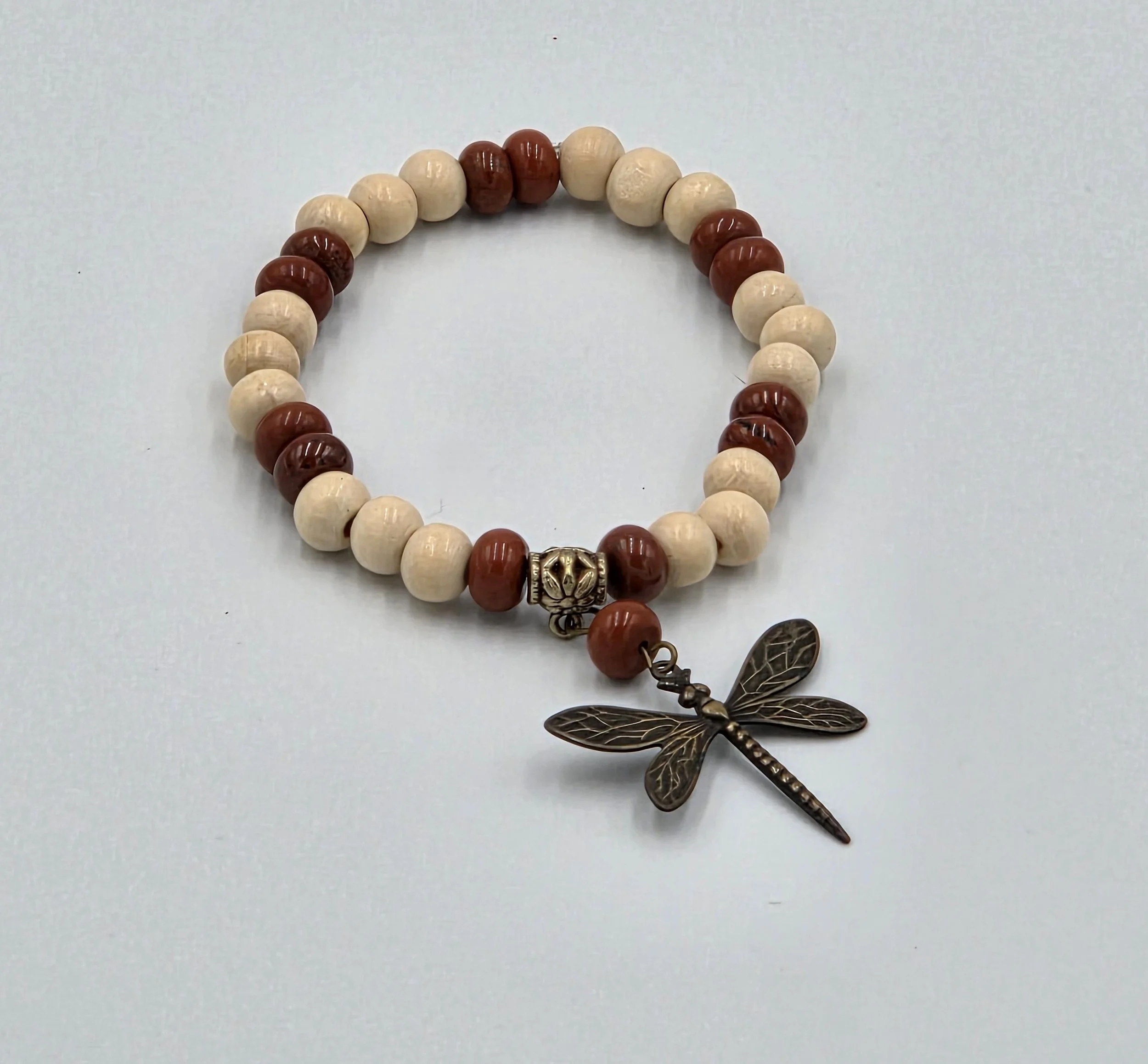 OOAK cream wood and matte red jasper bracelet with large bronze dragonfly charm.
