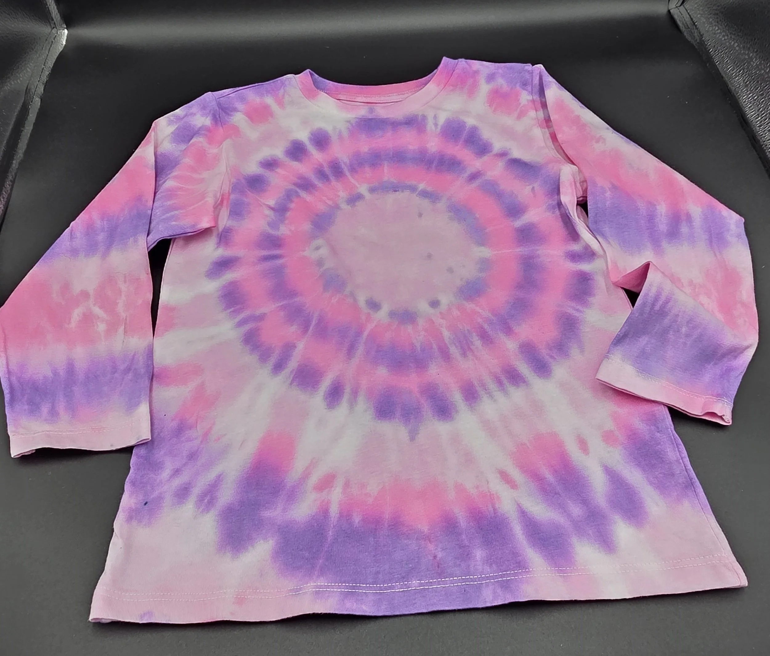Child's size 4 long-sleeved hand-dyed cotton T-shirt with a pink and purple concentric orbit pattern. OOAK textile art by Livity and the Creative i.