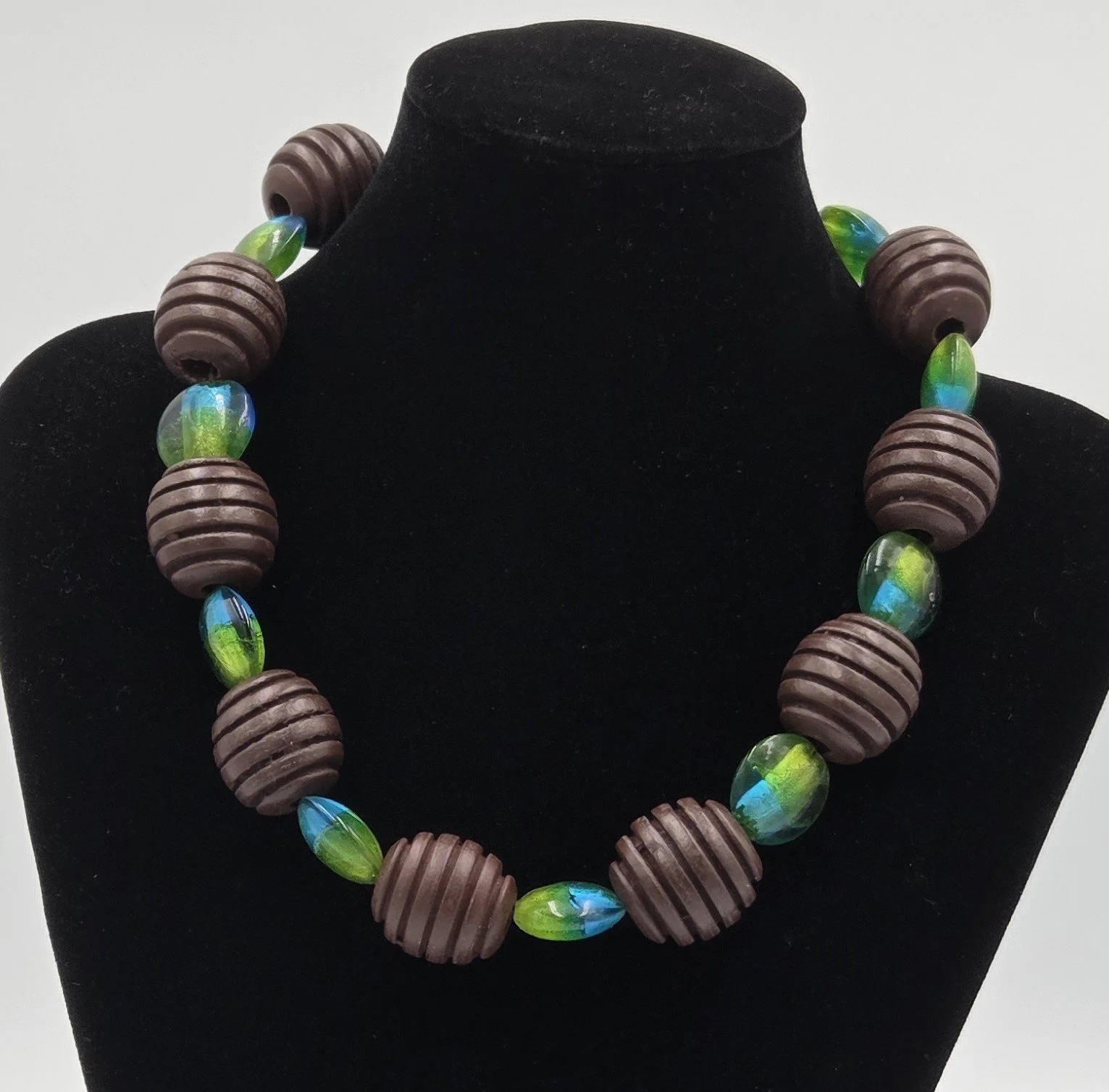 Choker necklace with large ribbed brown wood beads and blue-green foil glass beads.