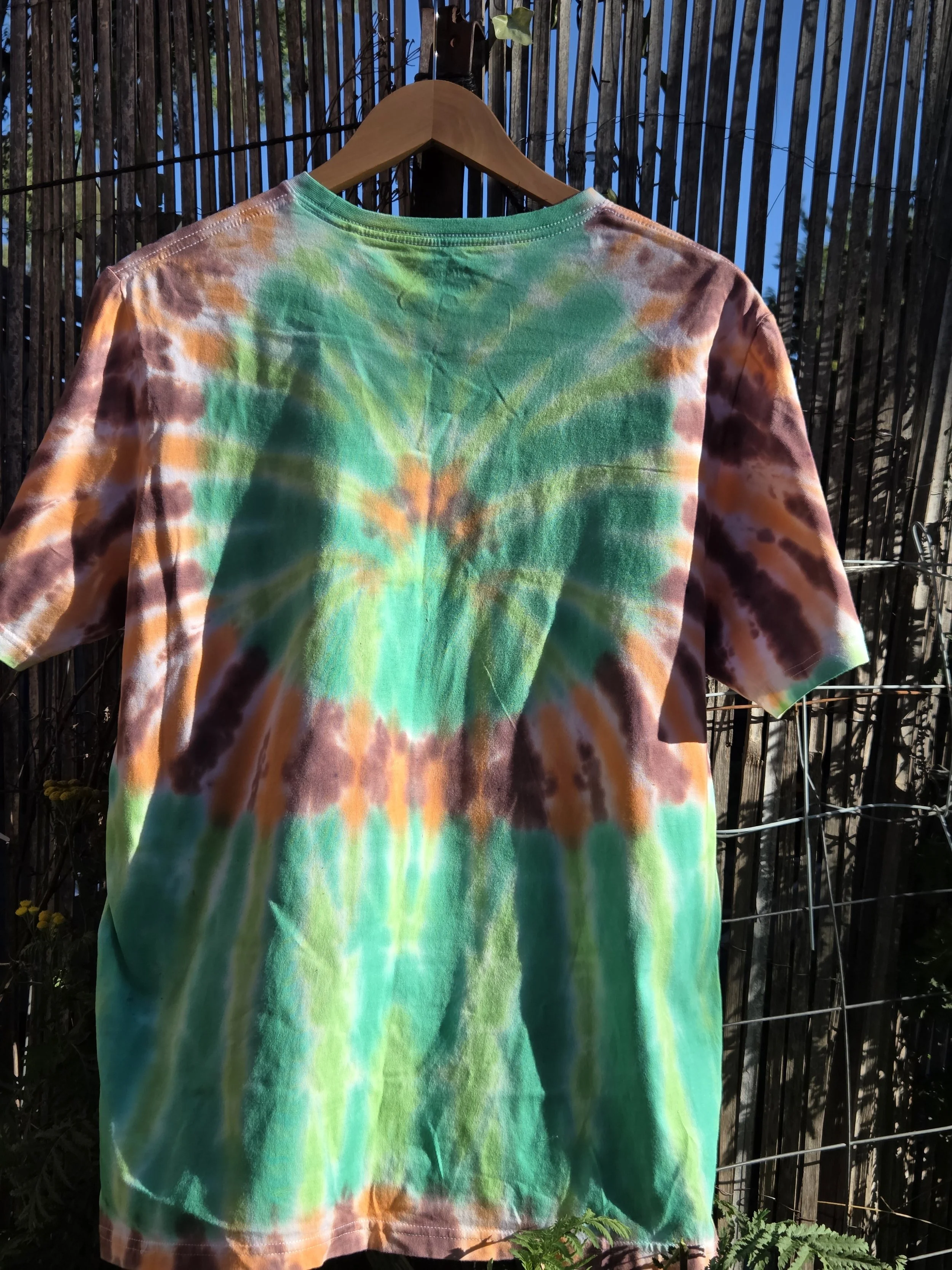 Adult Large hand-dyed green spider T-shirt with an orange and brown circular web frame. OOAK wearable art by Livity Studio Canberra."