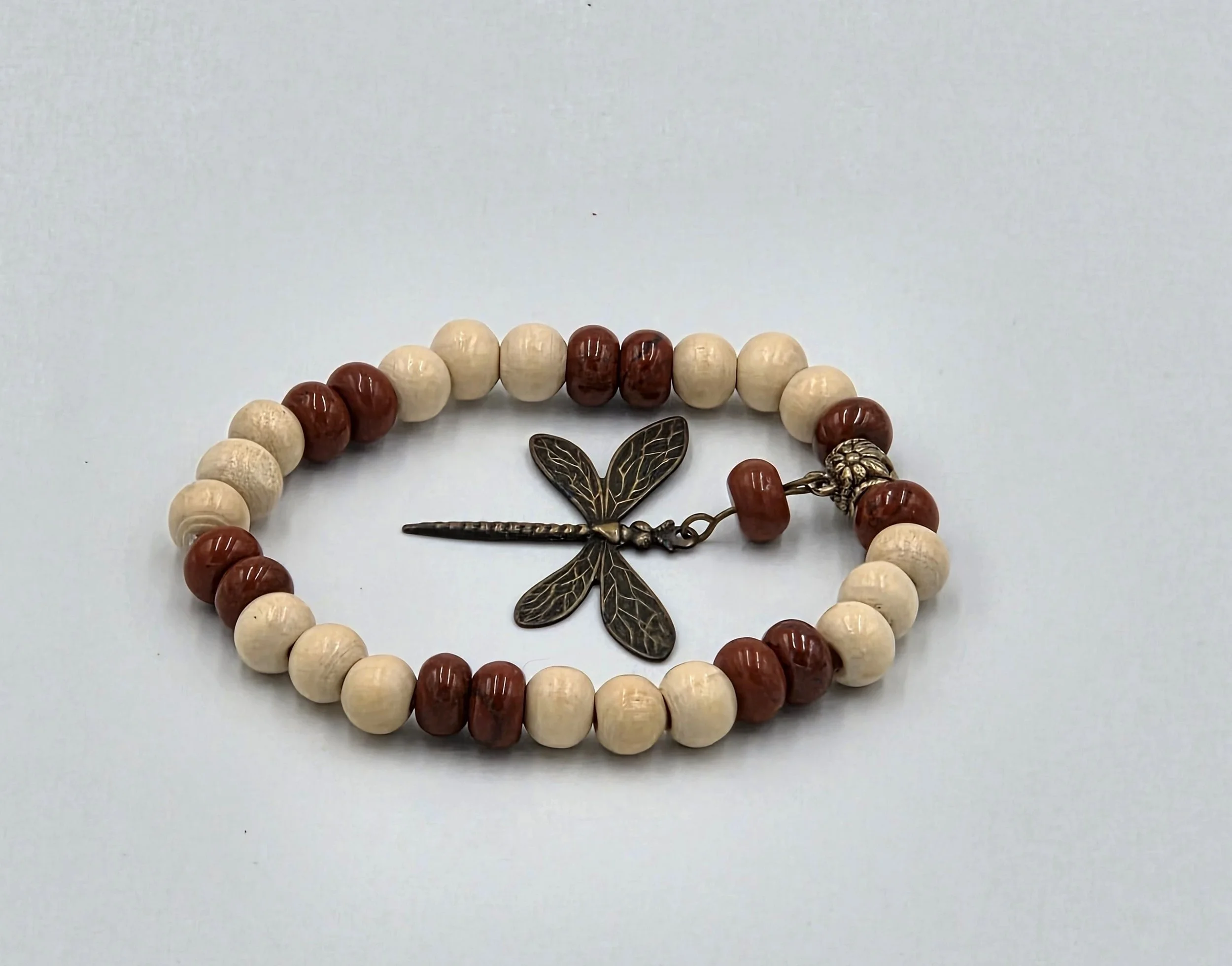 OOAK cream wood and matte red jasper bracelet with large bronze dragonfly charm.