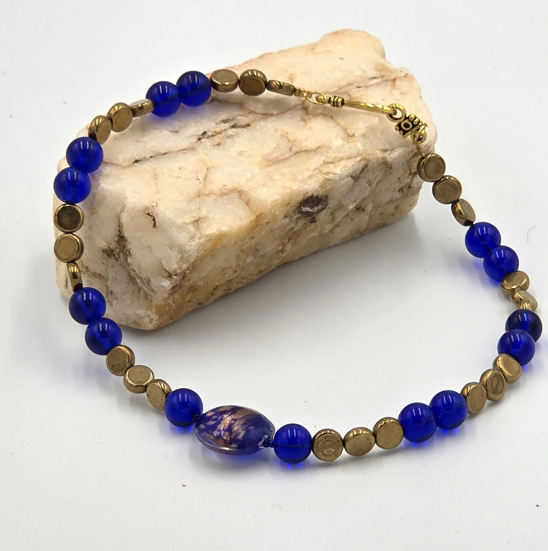 Dark blue and gold choker necklace with a large gold-foil glass bead