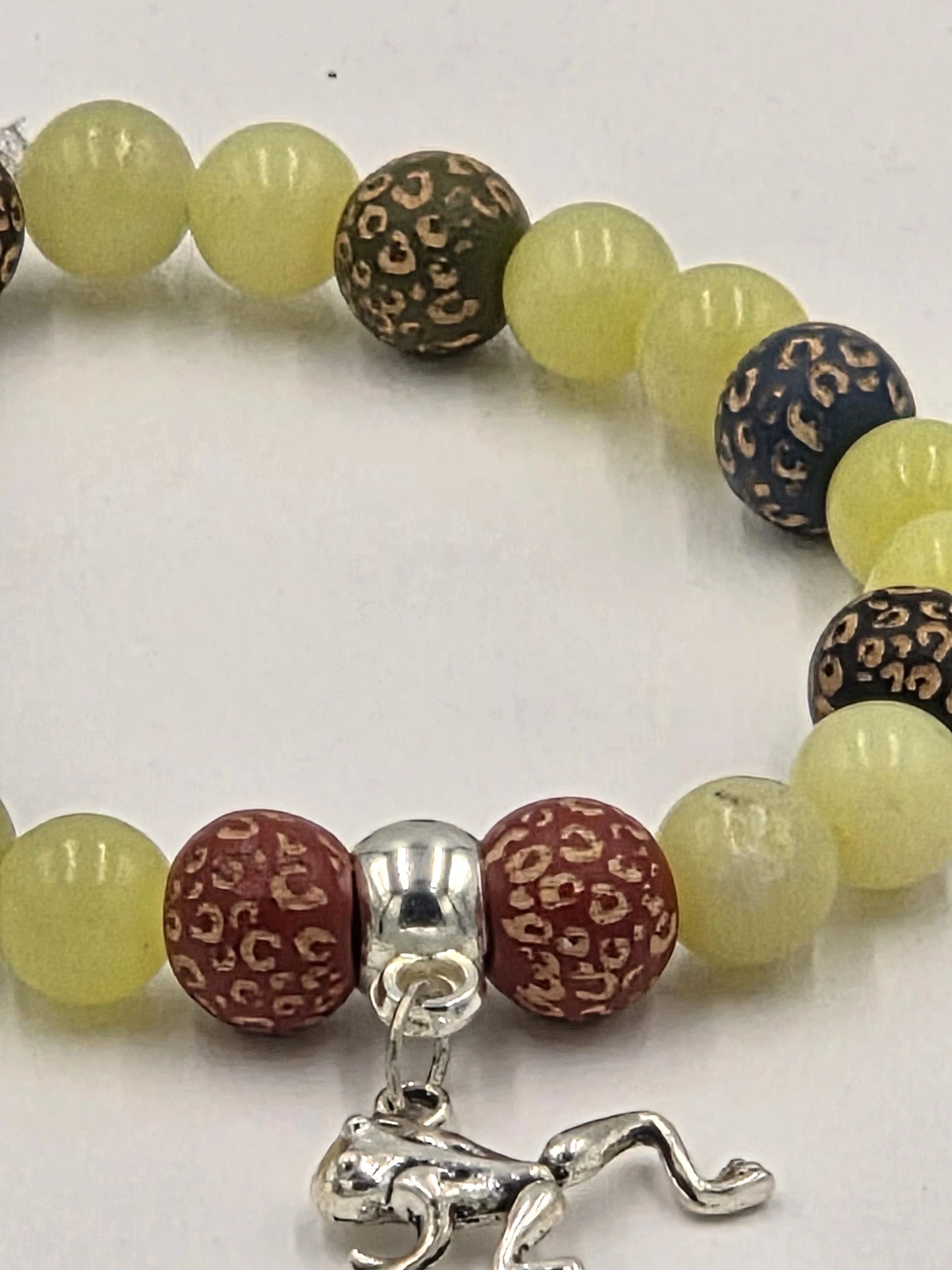 closse-up of OOAK lemon agate and muted leopard print wood bracelet with silver frog charm.