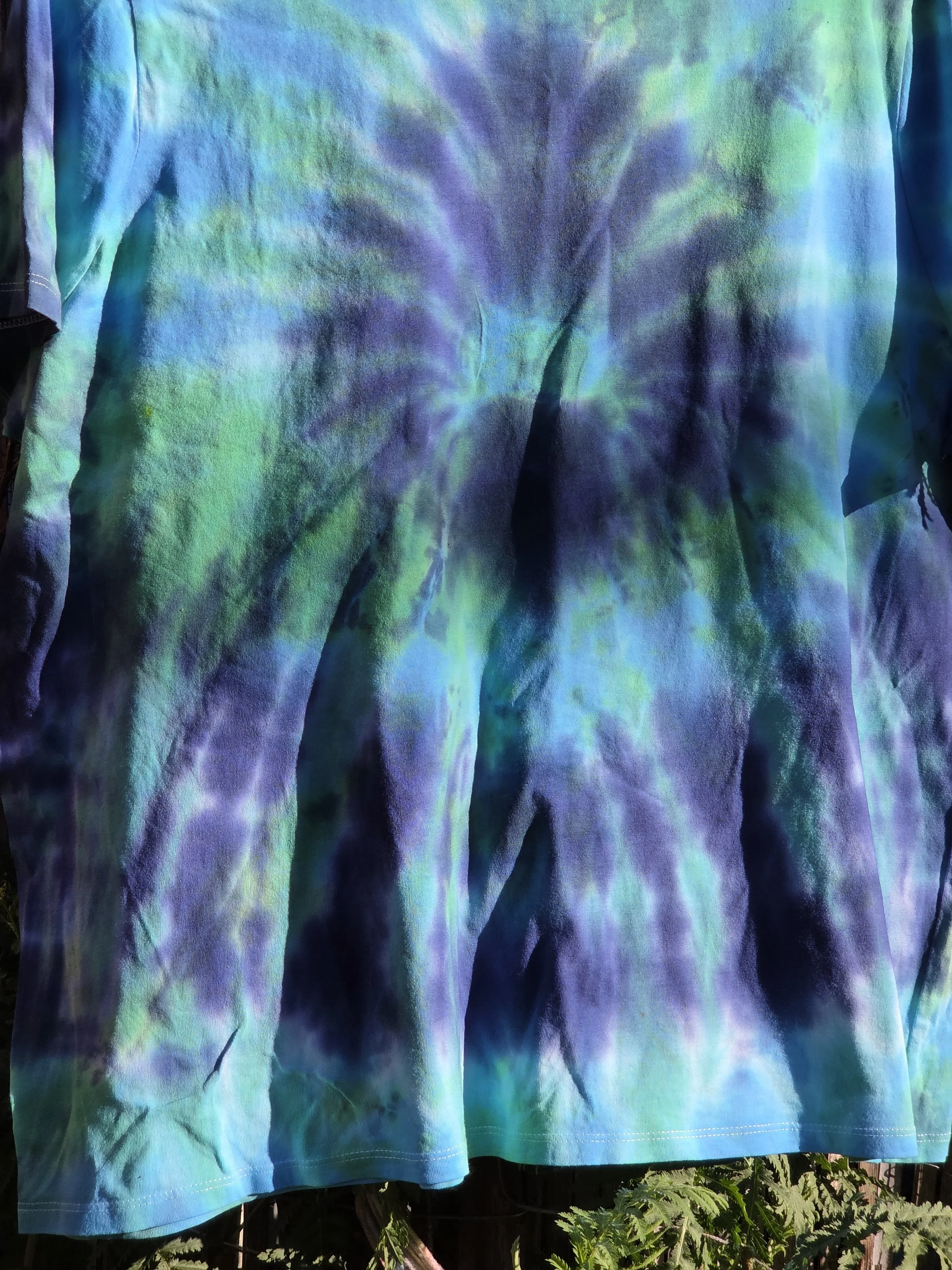 Size 20 adult hand-dyed t-shirt with a dark blue burst and spray pattern over pastel aquamarine. OOAK wearable art by Livity Studio."