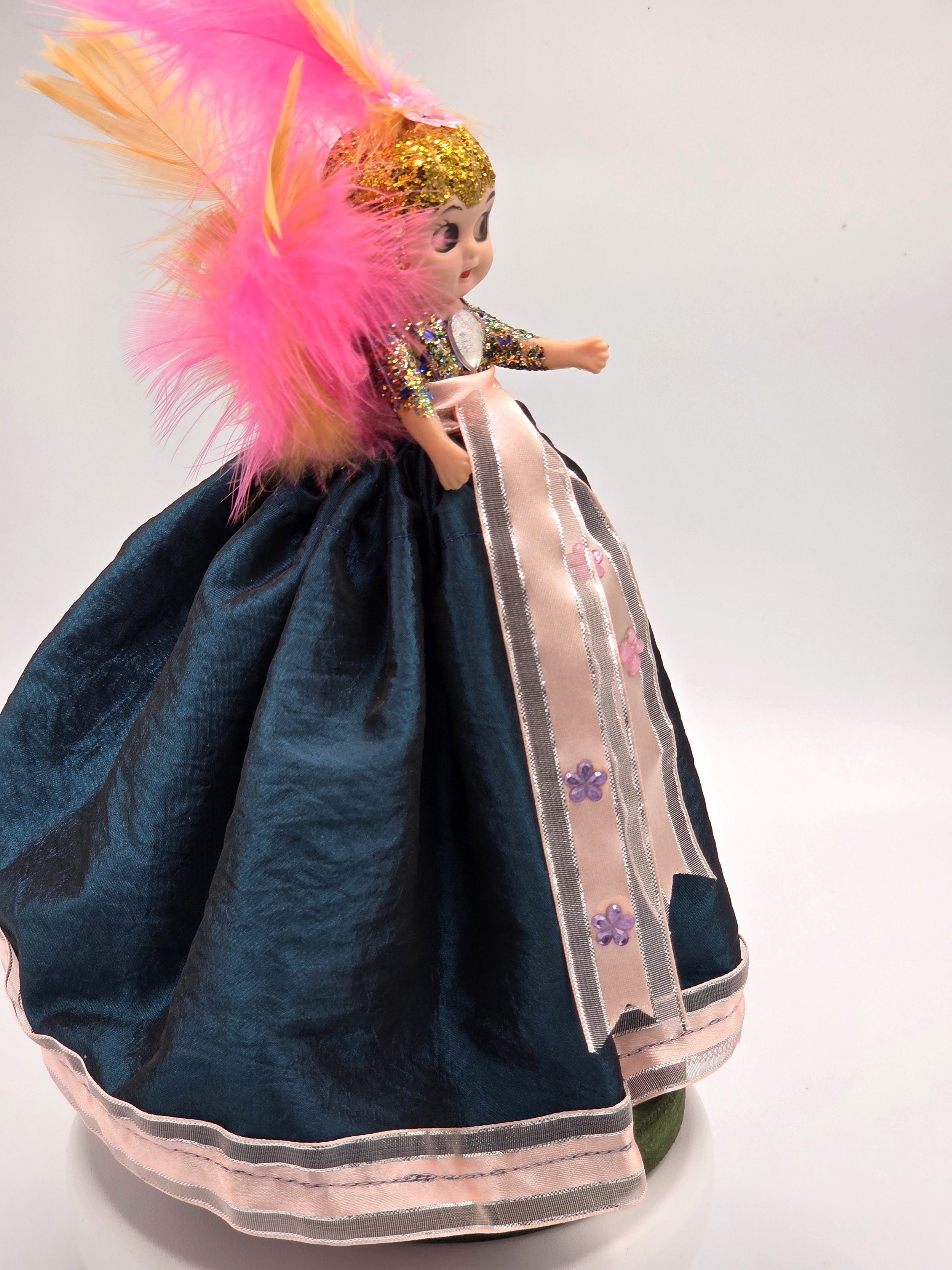side view Garden Sprite doll in evergreen taffeta with pink ribbon and feathers.