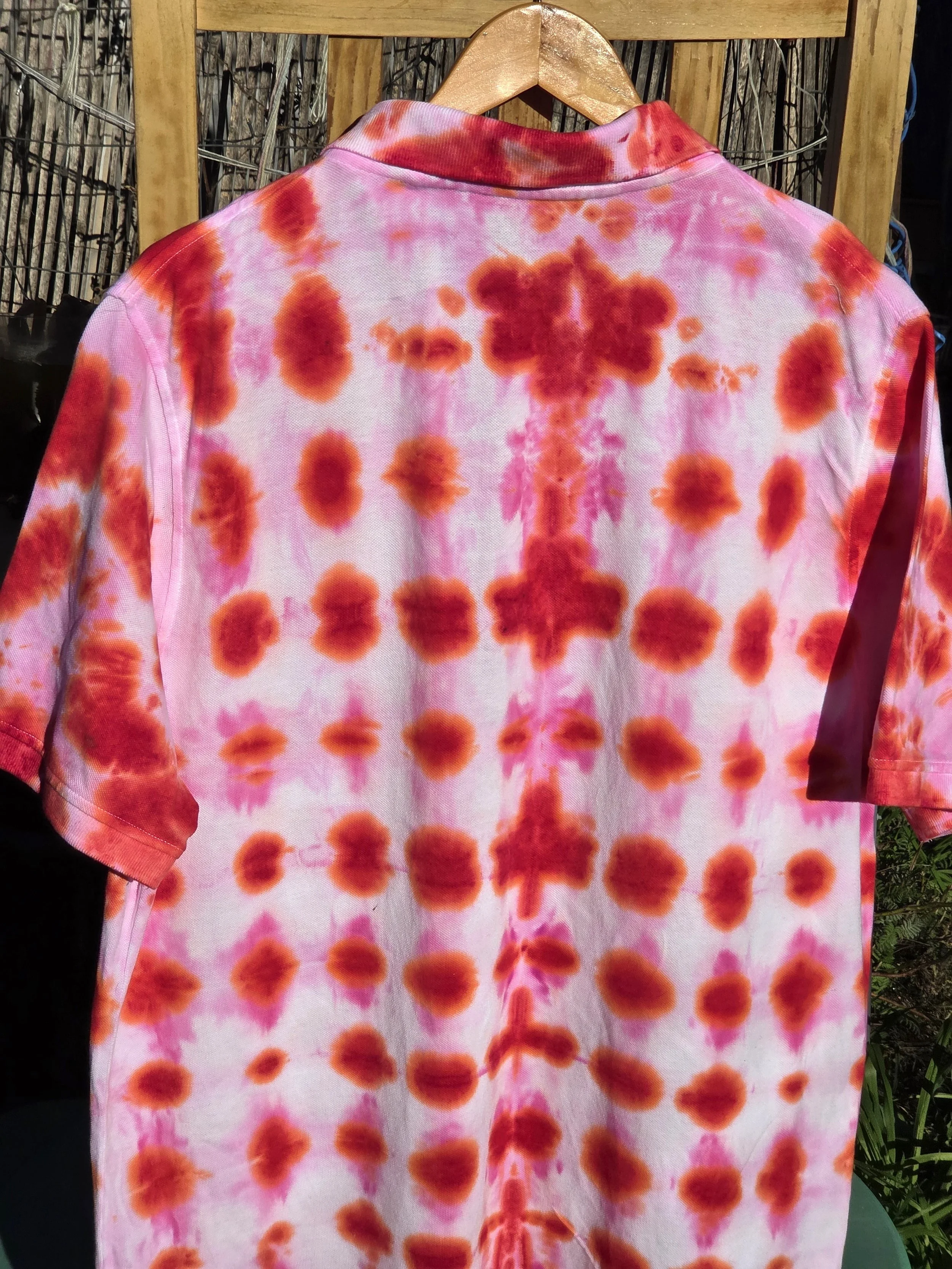 An adult size XL cotton polo shirt featuring a red tie-dye waffle weave pattern with lighter red bleeding into white negative space.